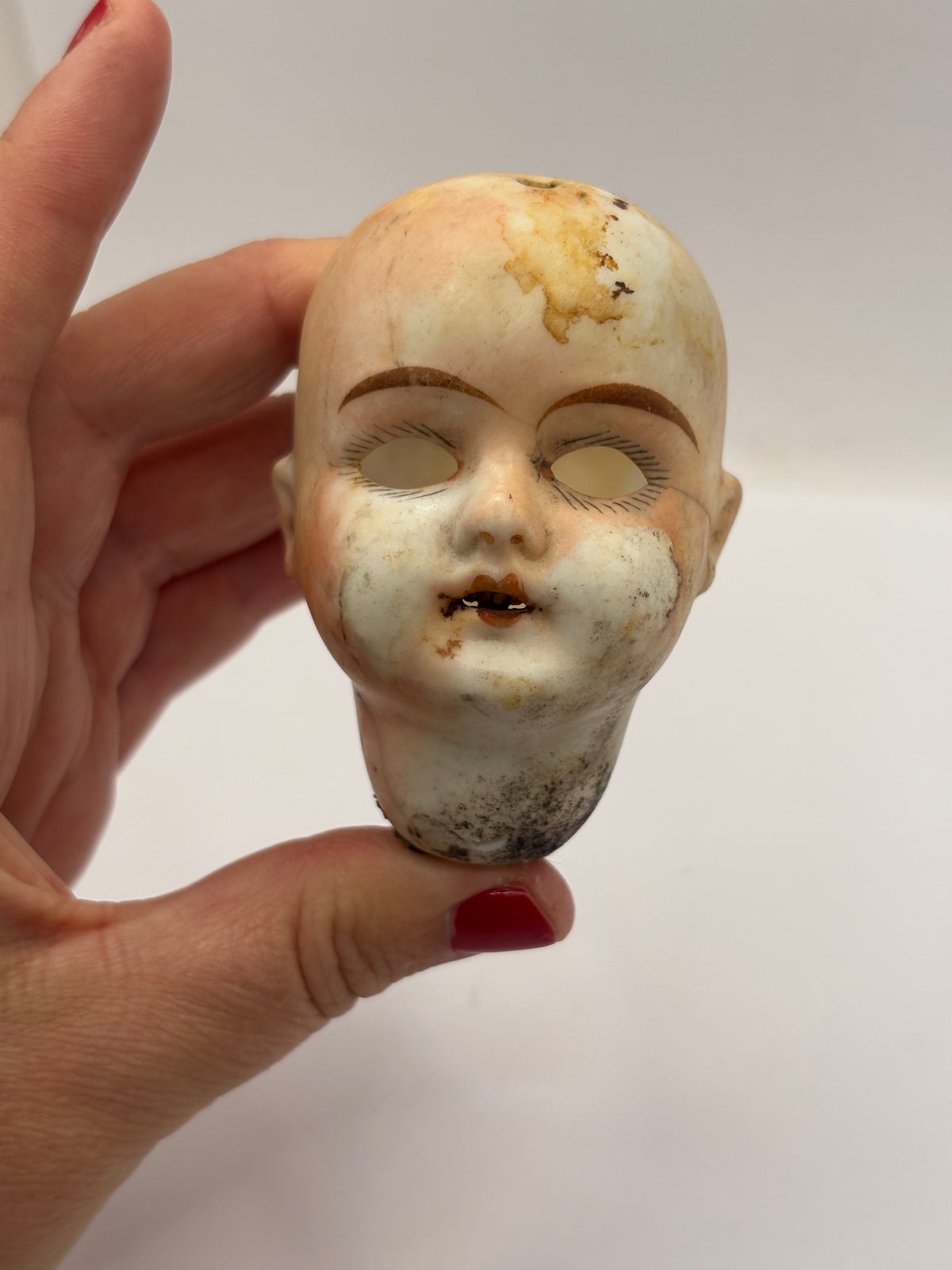 Old super stained bisque dolls head, damaged