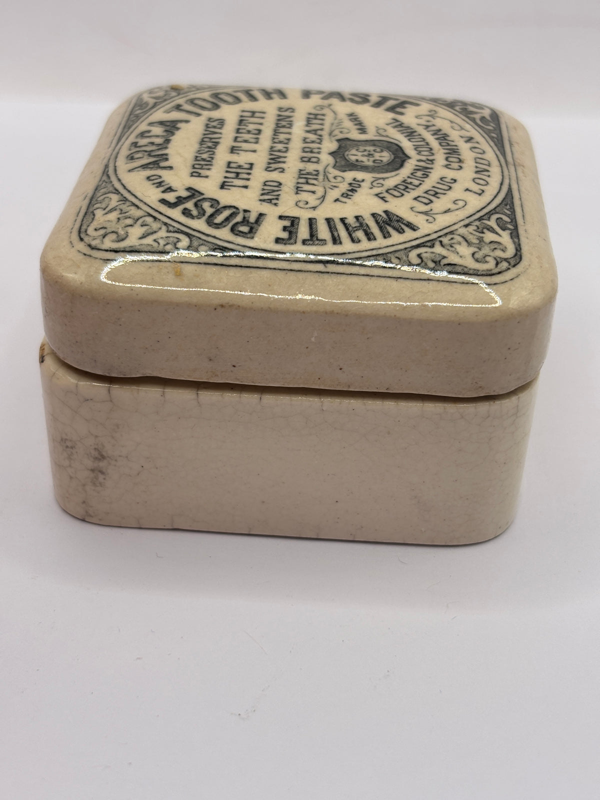 Old advertising lid and base. White rose and areca toothpaste. Damaged