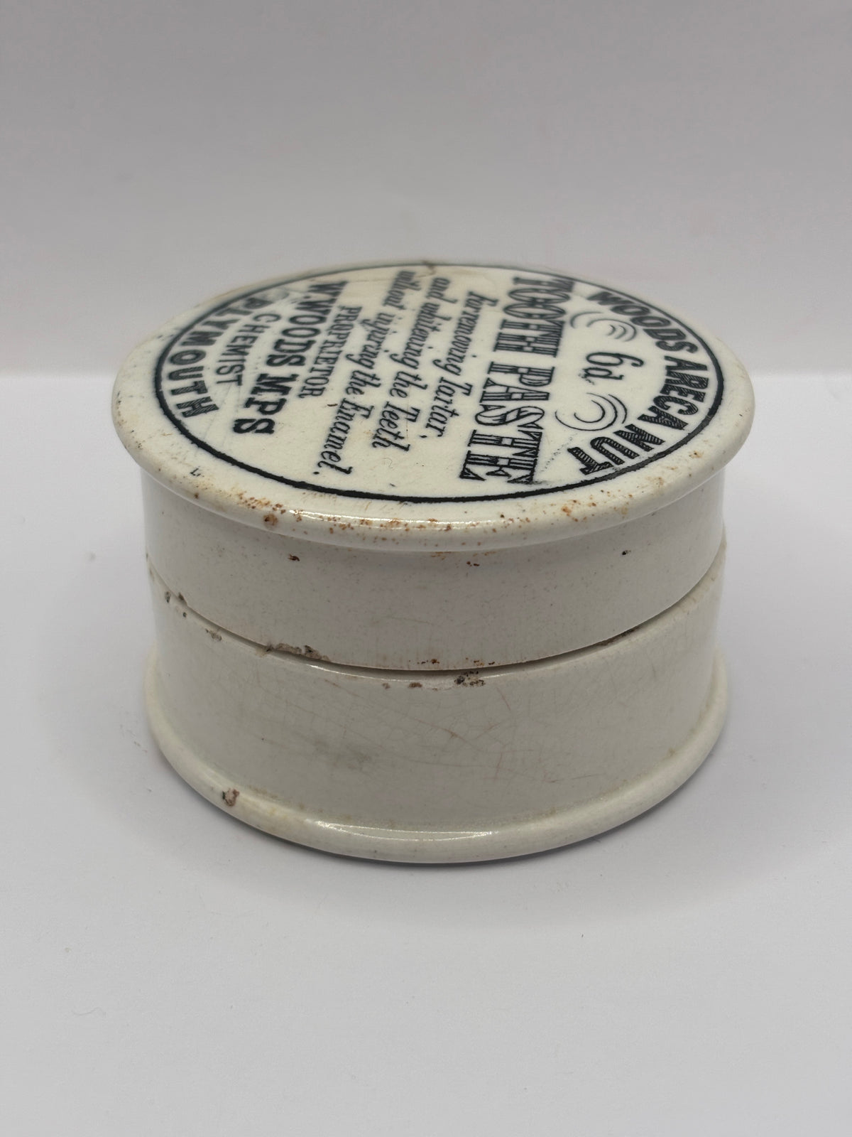 Old advertising lid and base. Woods areca nut tooth paste. Damaged