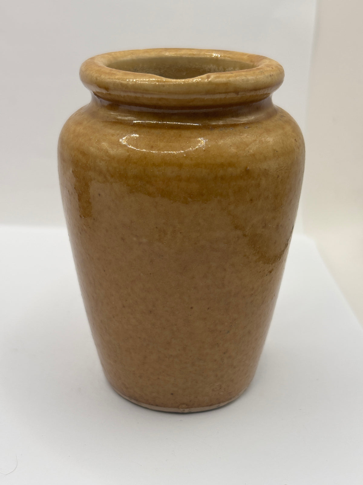 Old brown stoneware cream pot, pouring cream