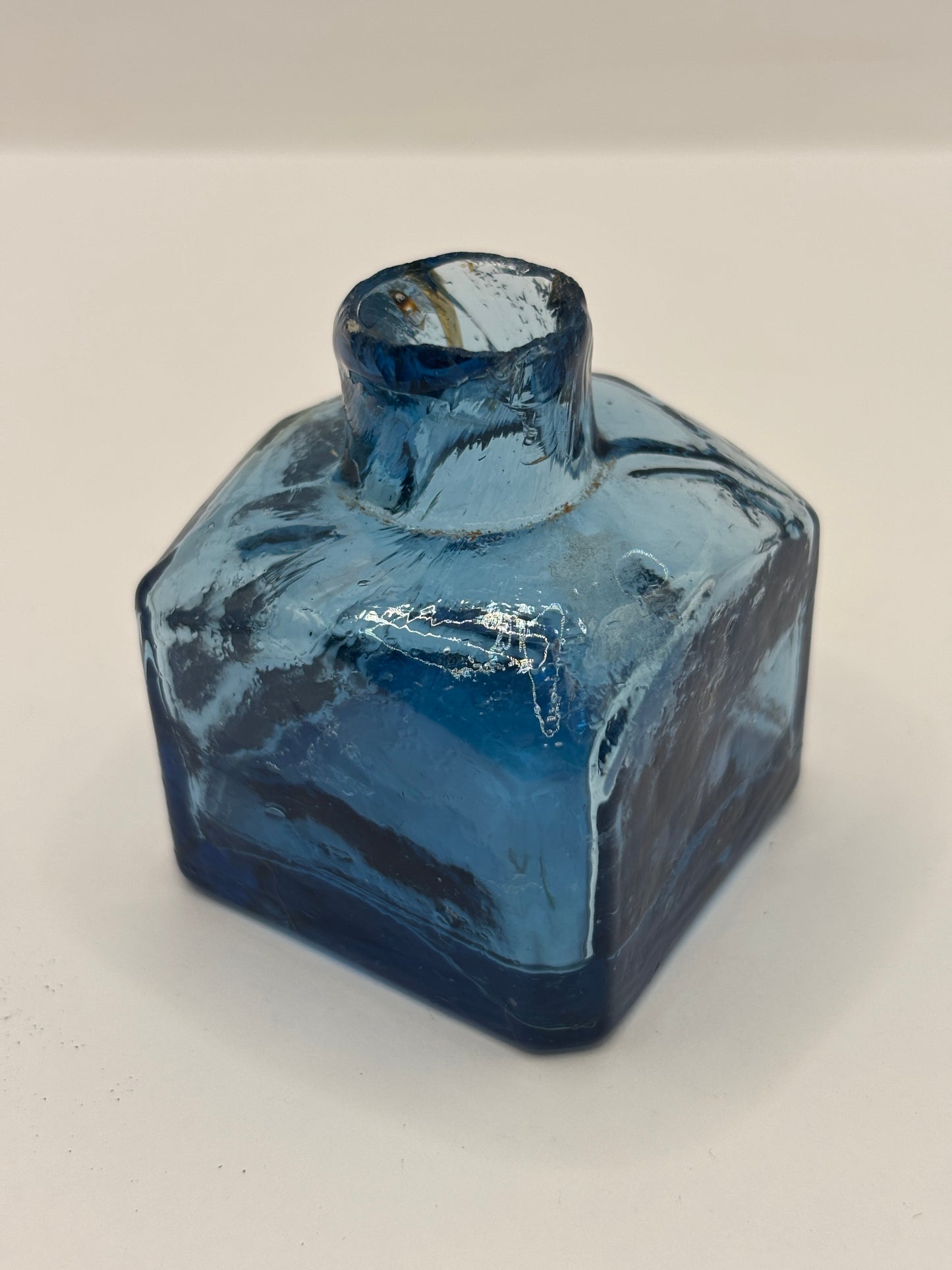 Old blue glass inkwell, penny ink with swirls. Damaged