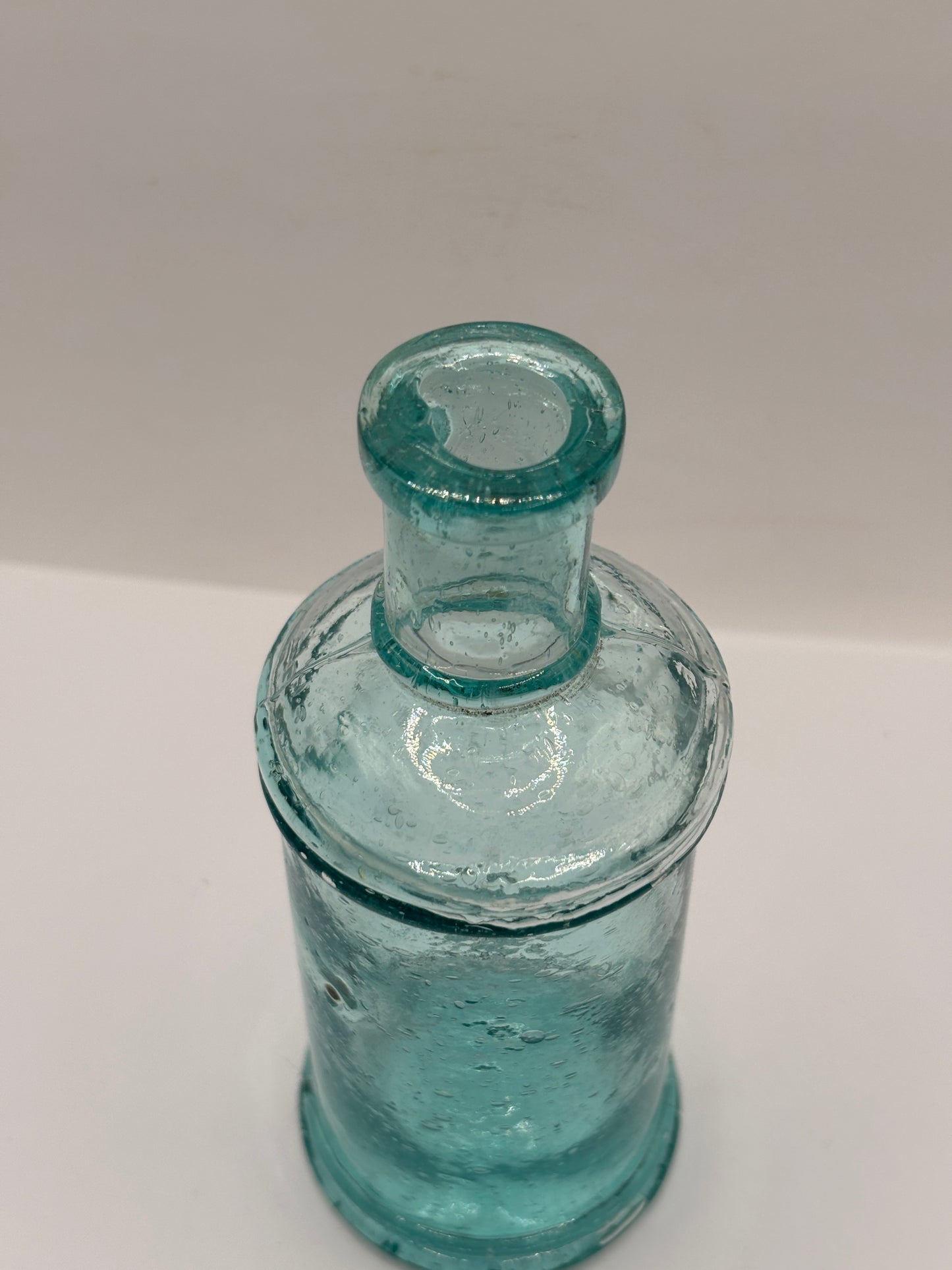 Old tall aqua glass pouring ink, ink bottle