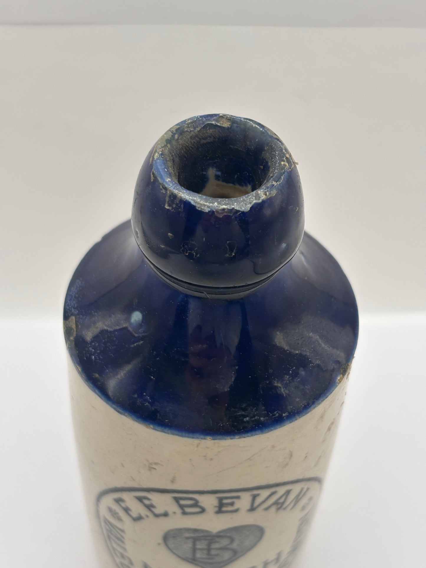 Old blue top stoneware ginger beer bottle, E.E Bevan Neath Brewery