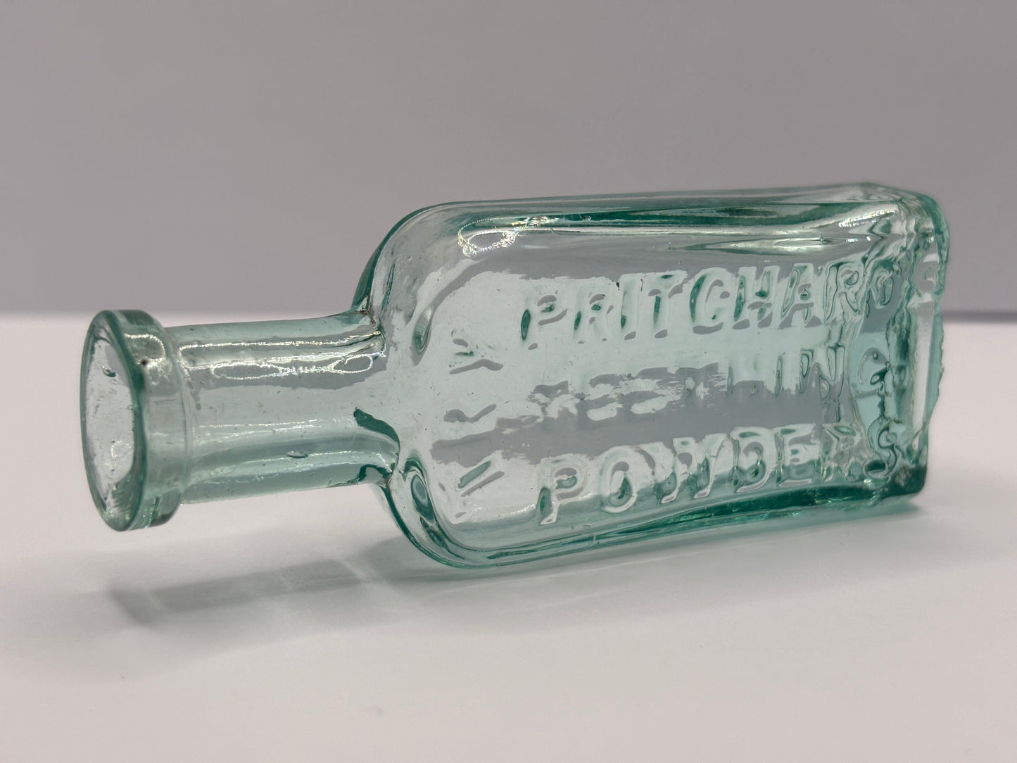 Old aqua glass advertising chemist bottle. Pritchards teething powder