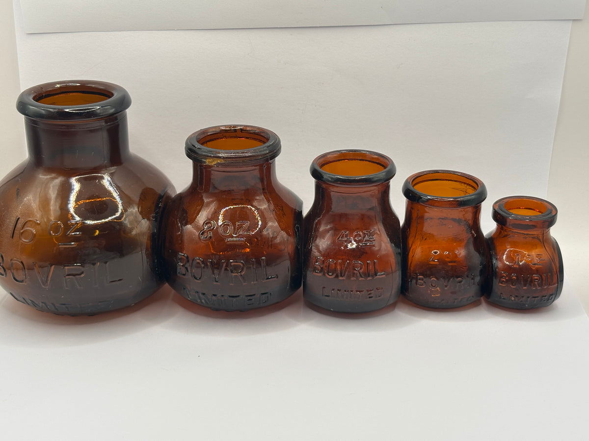 Set of 5 old amber glass Bovril bottles. 16oz- 1oz