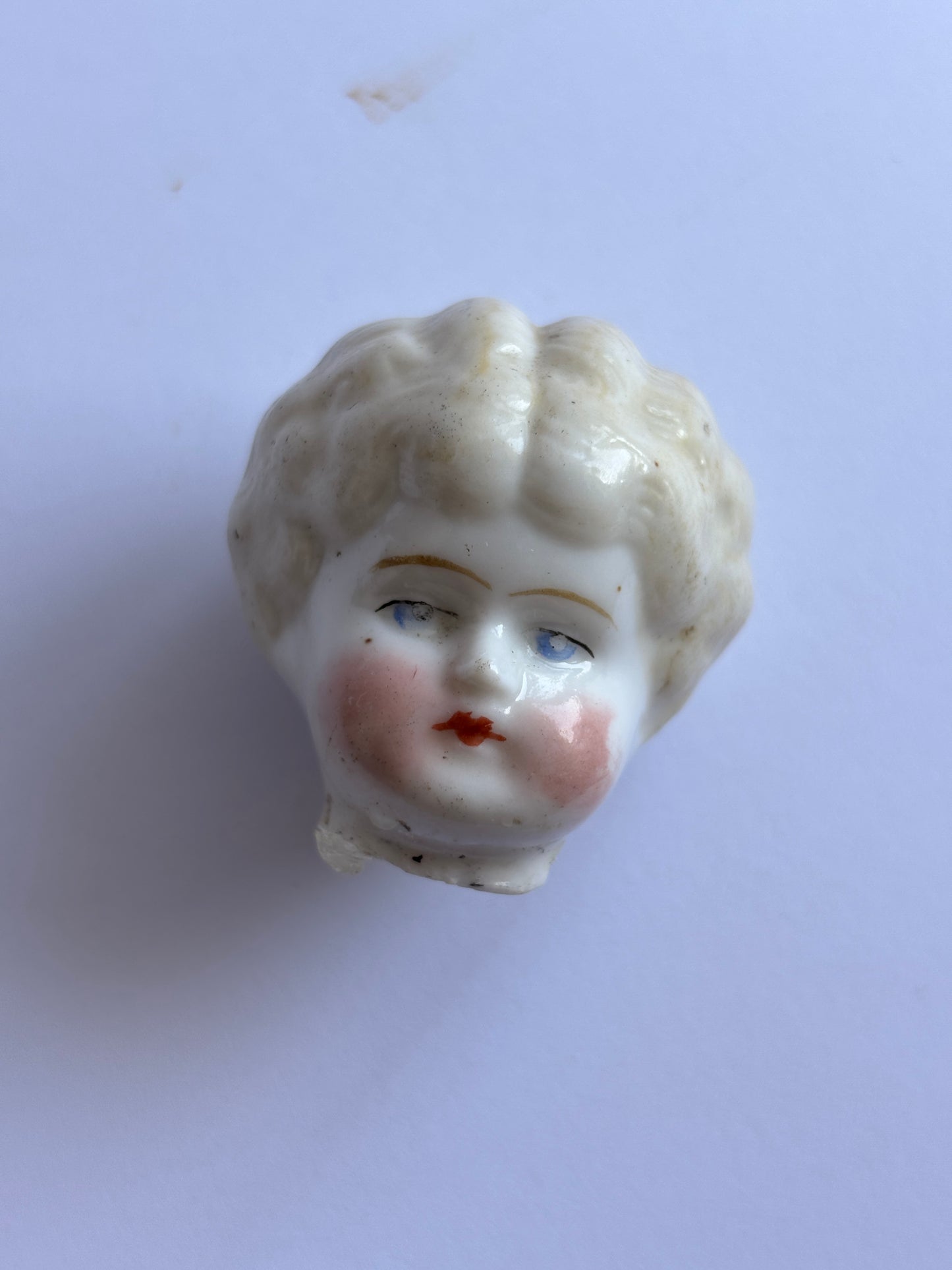 Old small damaged dolls head