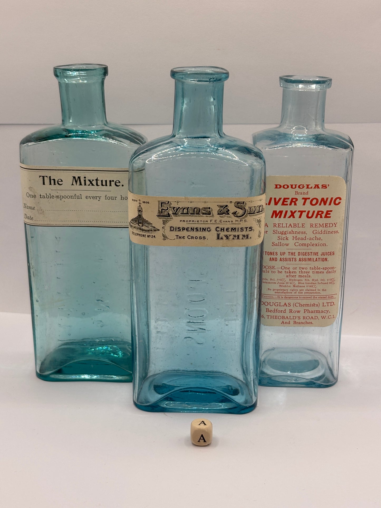 3 old glass chemist bottles with added labels (a)