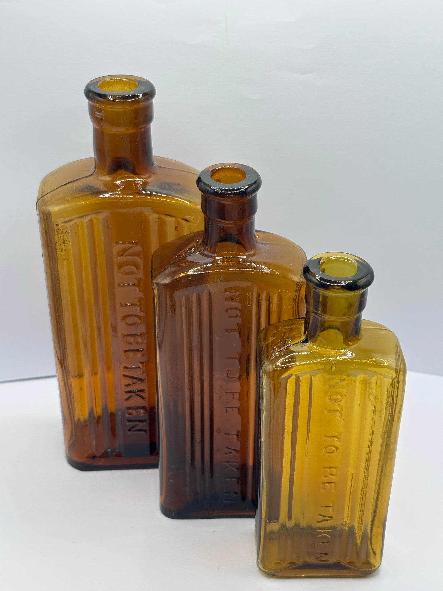 3 old amber glass poison bottles, not to be taken. Halloween