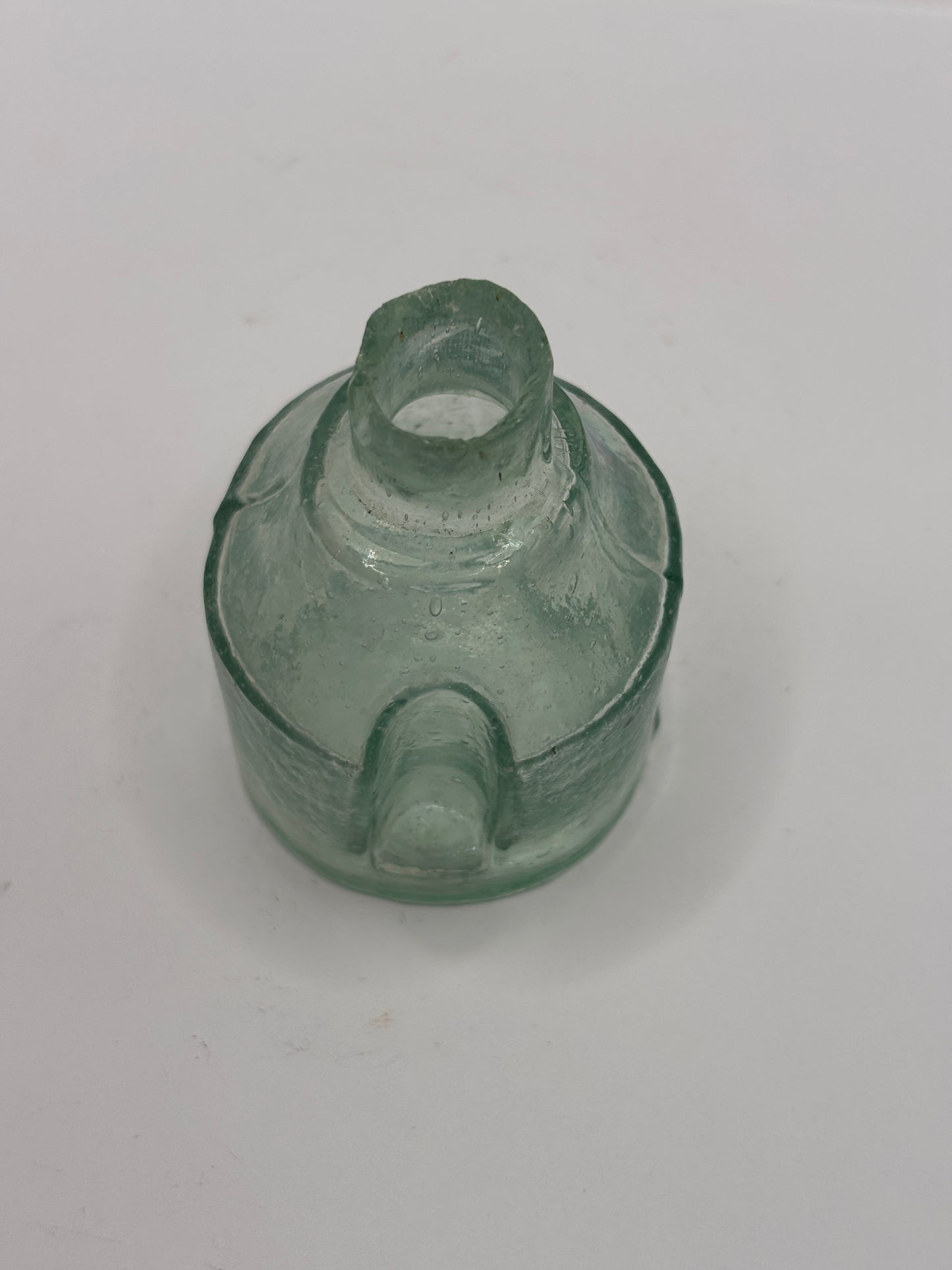 Old round aqua glass inkwell. Ink bottle with pen rest