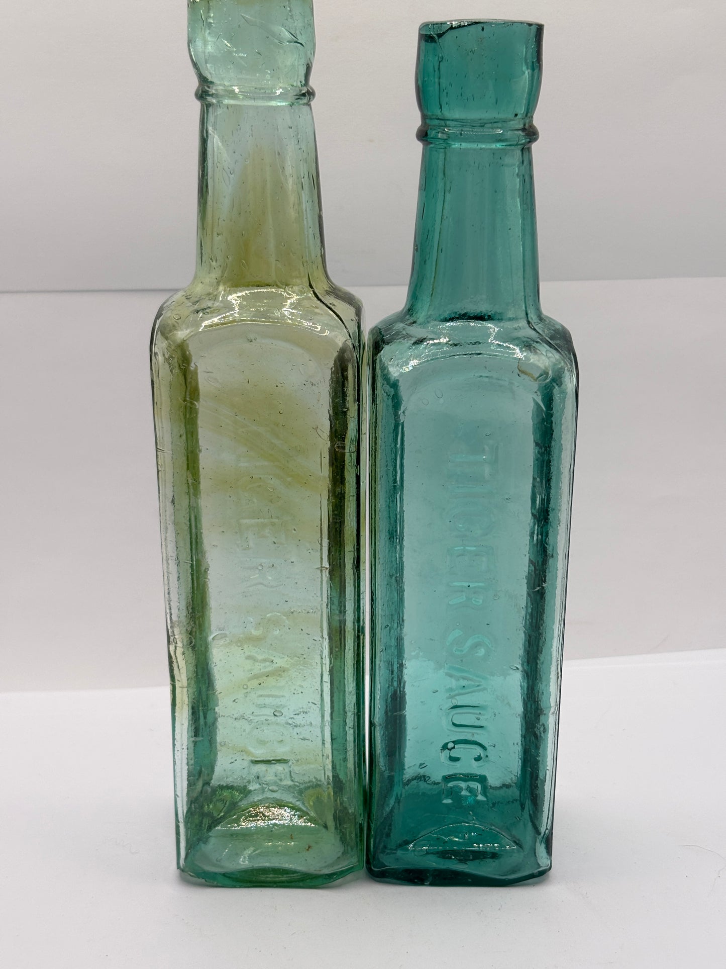 2 old aqua glass sauce bottles, Fletcher’s tiger sauce