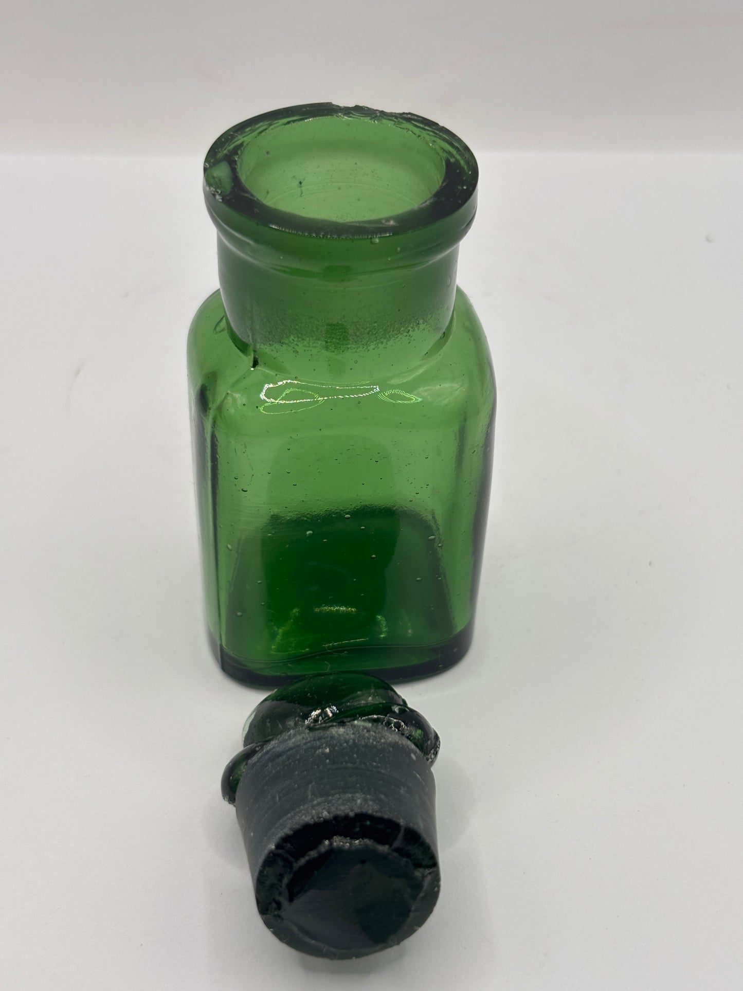 Old green glass smelling salts bottle, chipped
