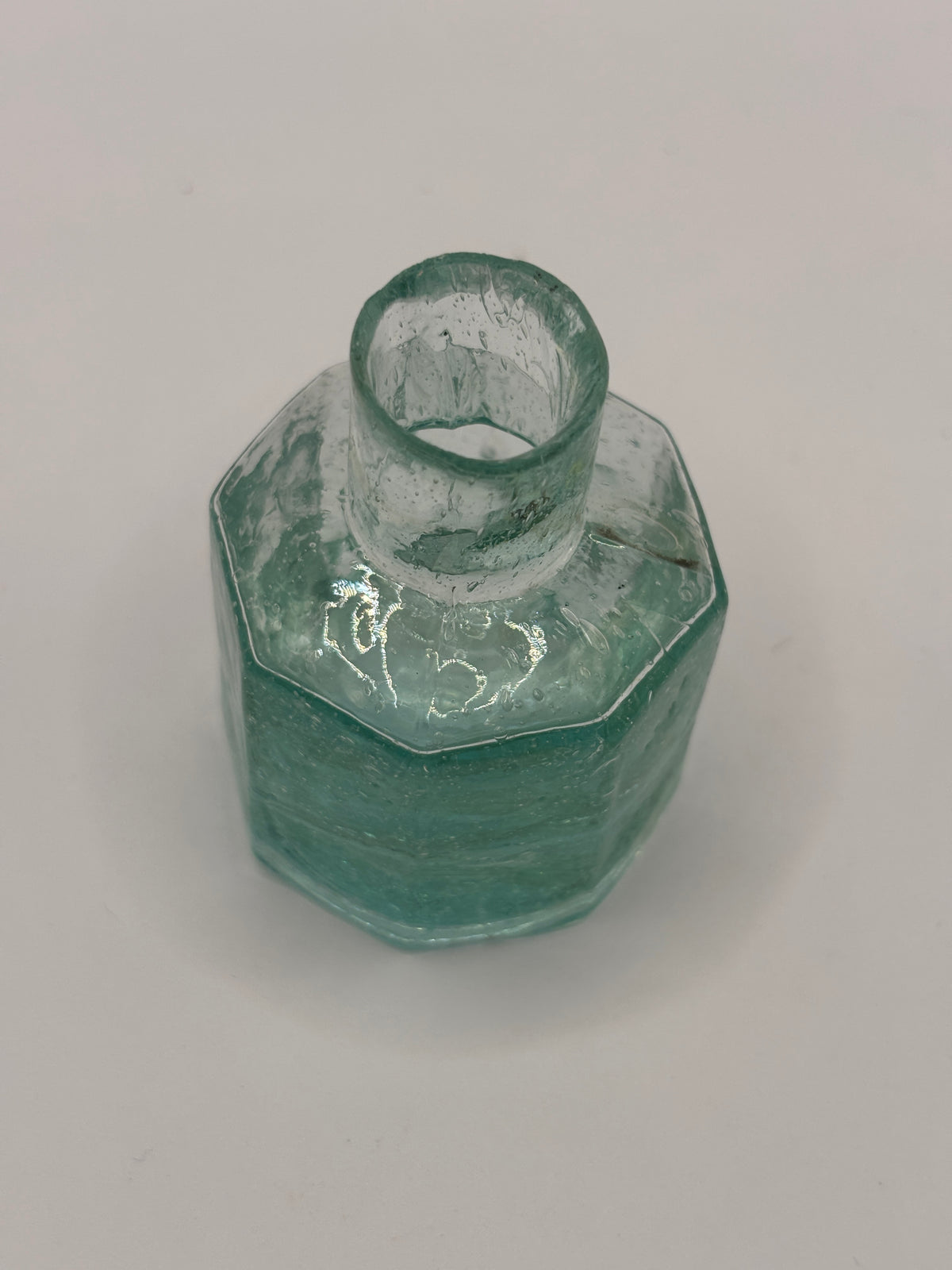 Old aqua glass inkwell, bubbly ink