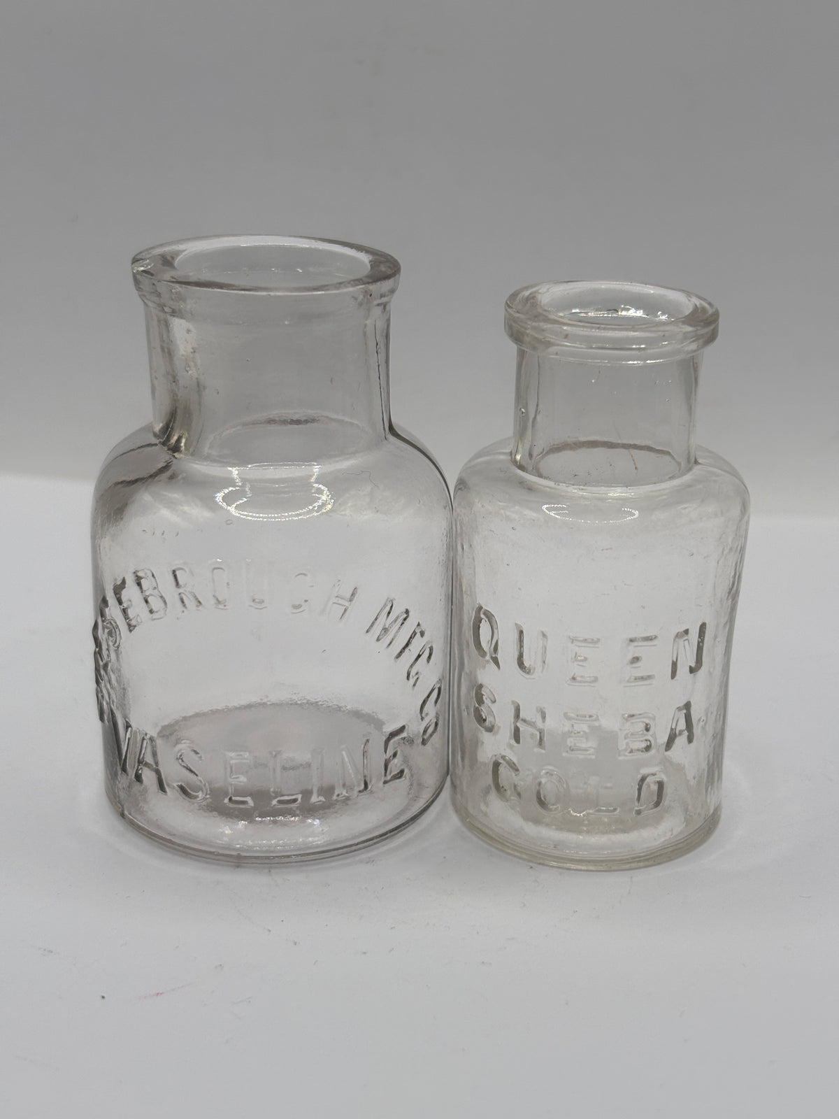 2 small clear glass advertising jars
