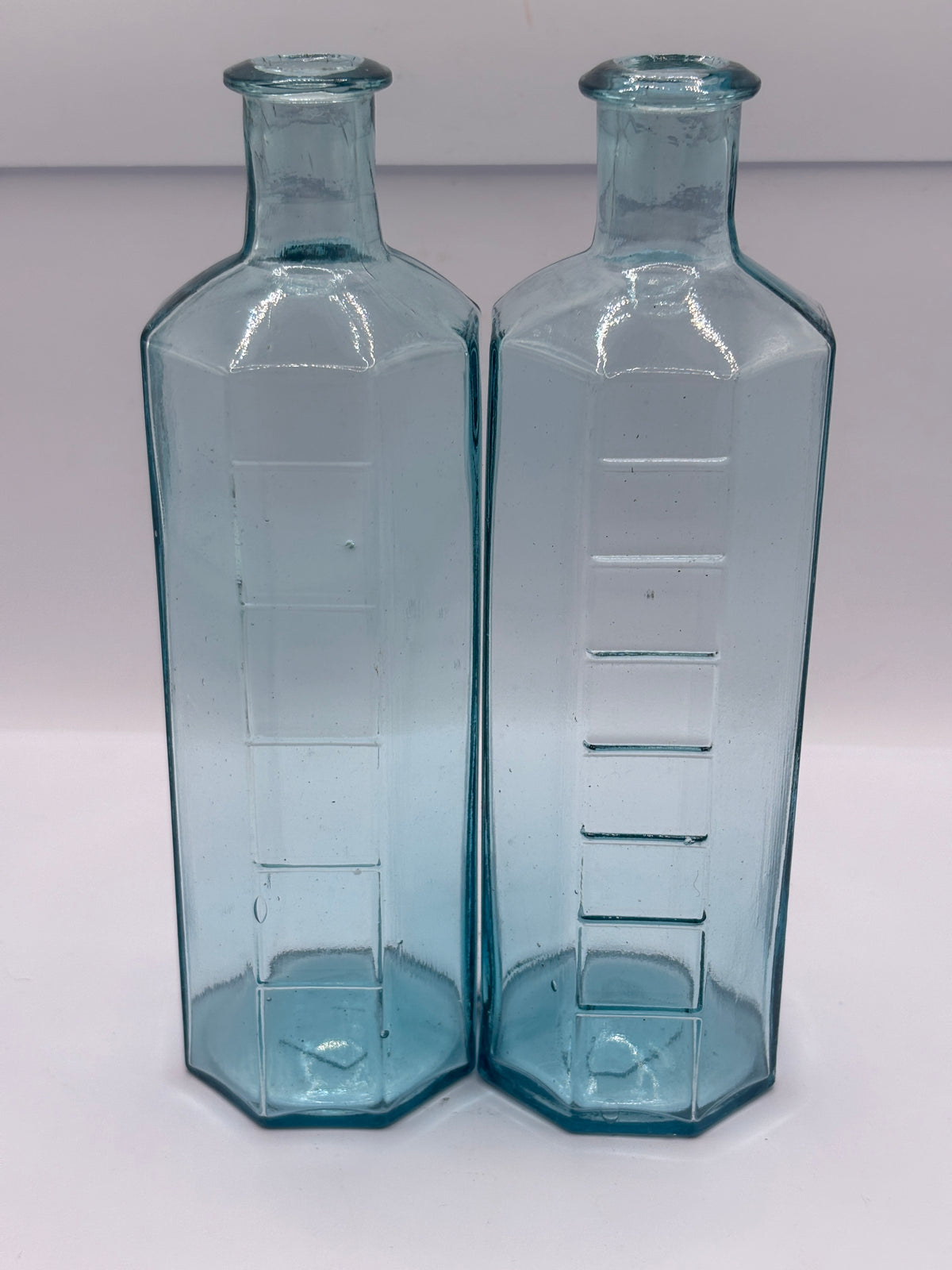 2 old glass medicine bottles