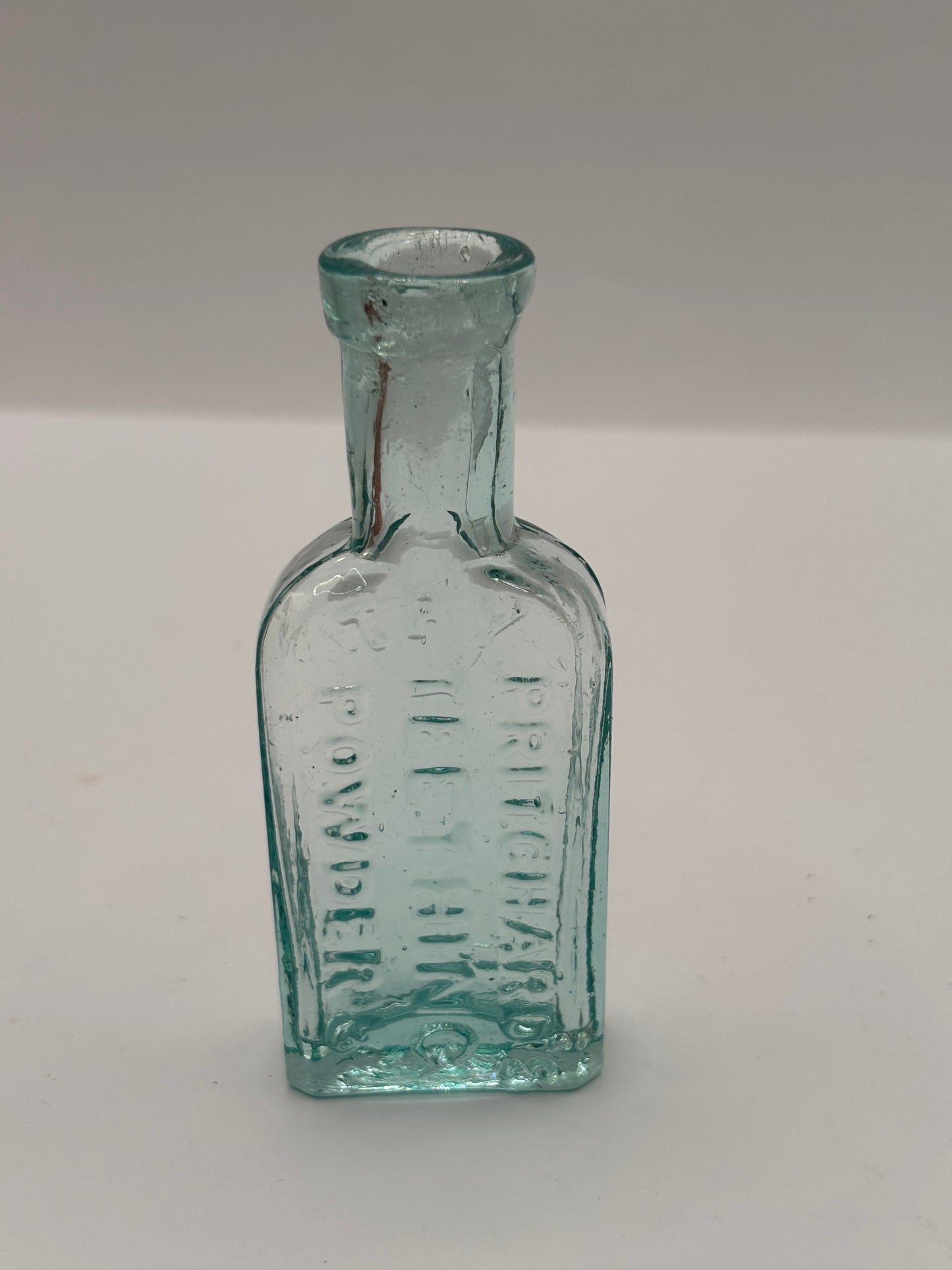 Old small aqua glass advertising bottle. Pritchards teething powders