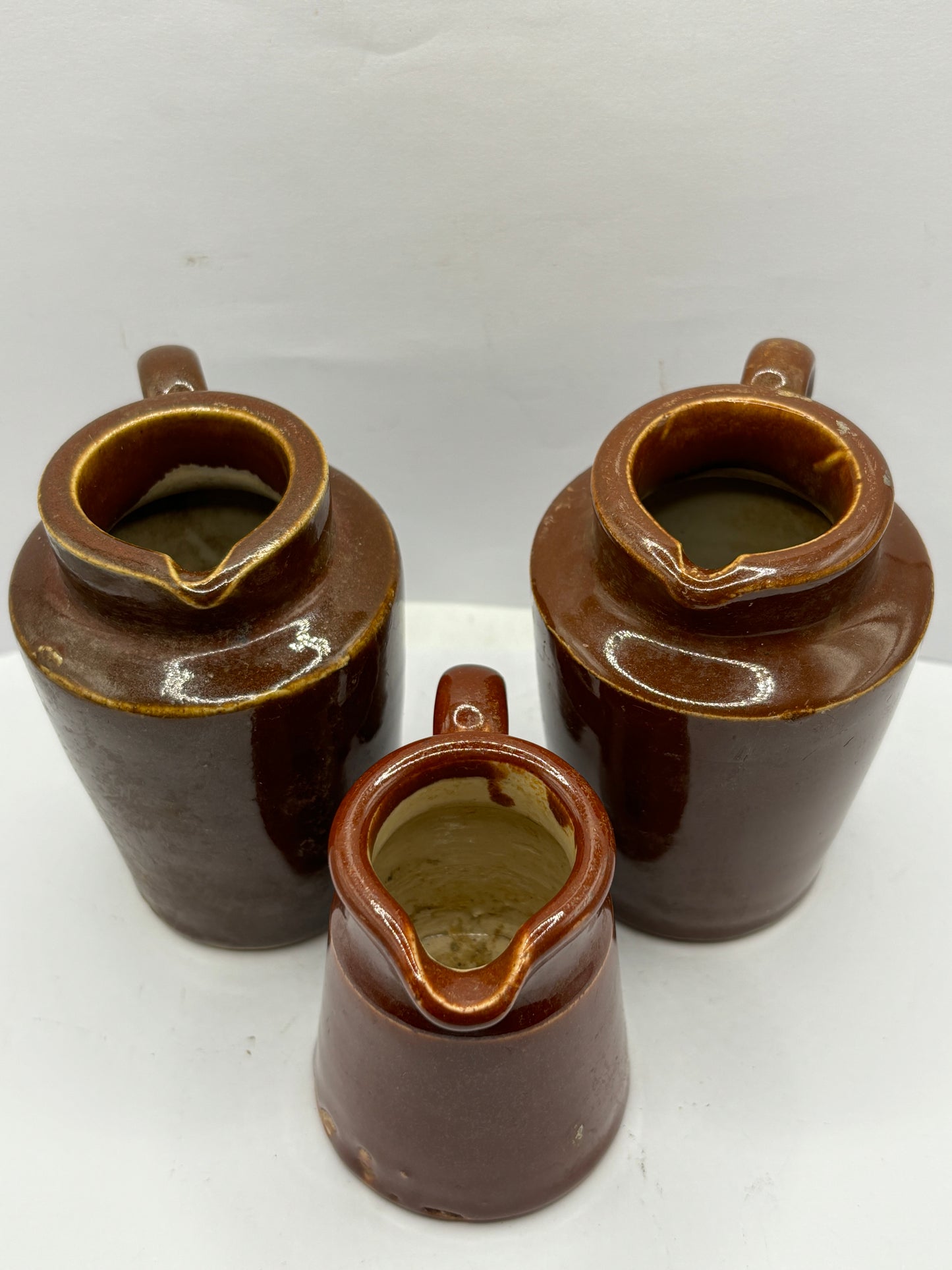 3 old brown stoneware cream pots, handled