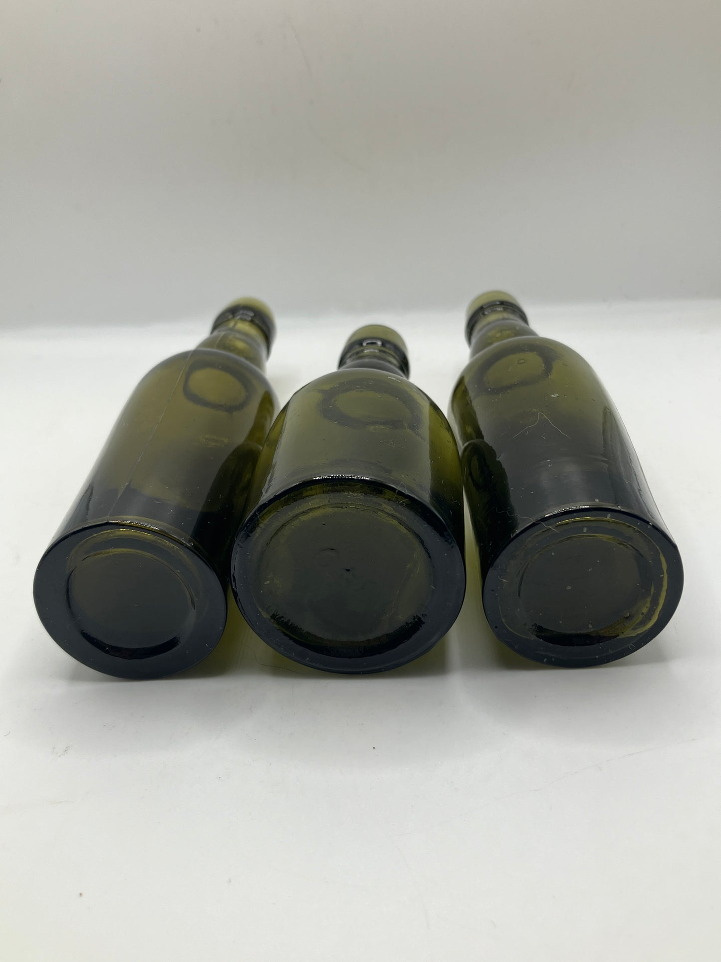 3 small green glass whisky bottles