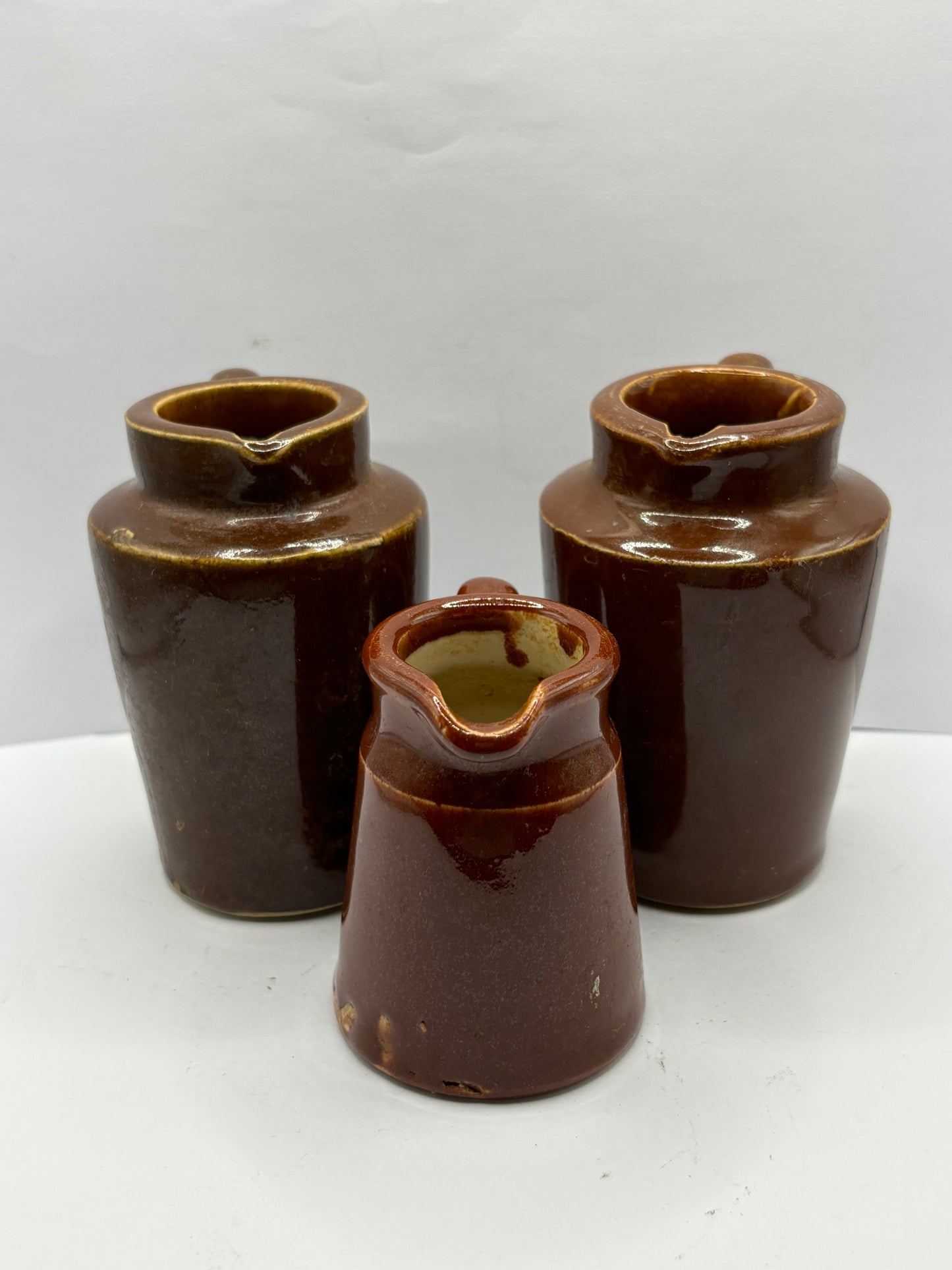 3 old brown stoneware cream pots, handled