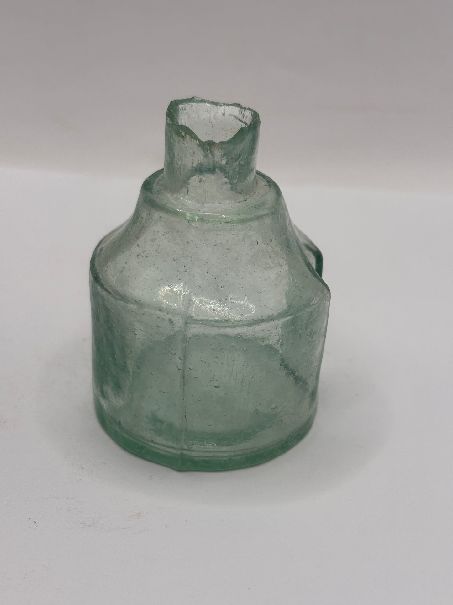 Old round aqua glass inkwell. Ink bottle with pen rest