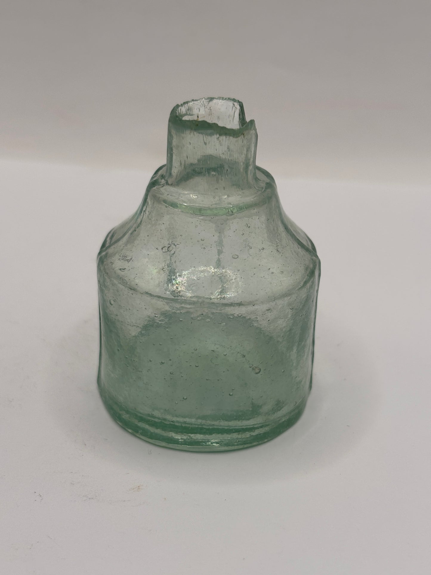 Old round aqua glass inkwell. Ink bottle with pen rest