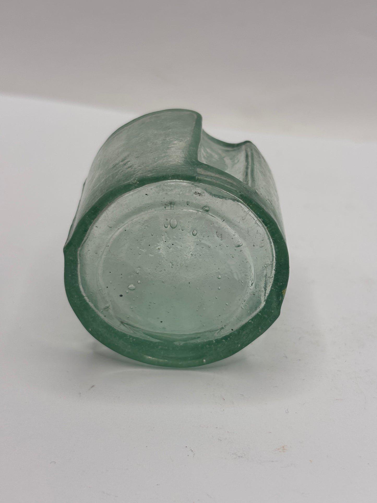 Old round aqua glass inkwell. Ink bottle with pen rest