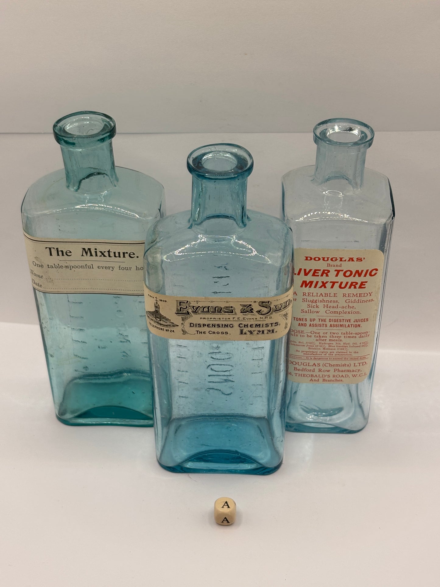 3 old glass chemist bottles with added labels (a)