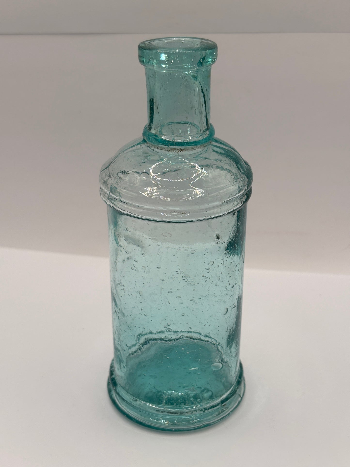 Old tall aqua glass pouring ink, ink bottle