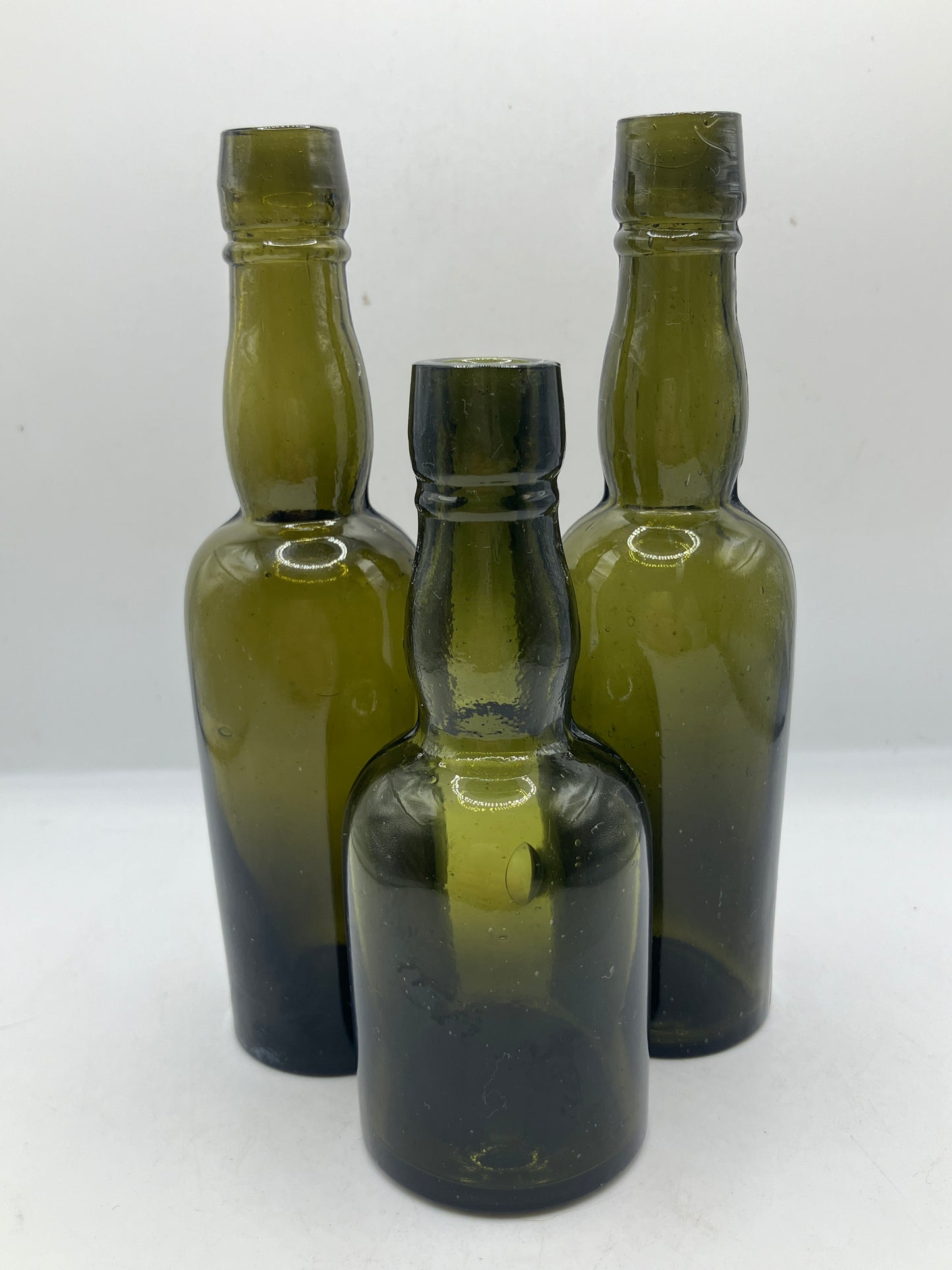 3 small green glass whisky bottles