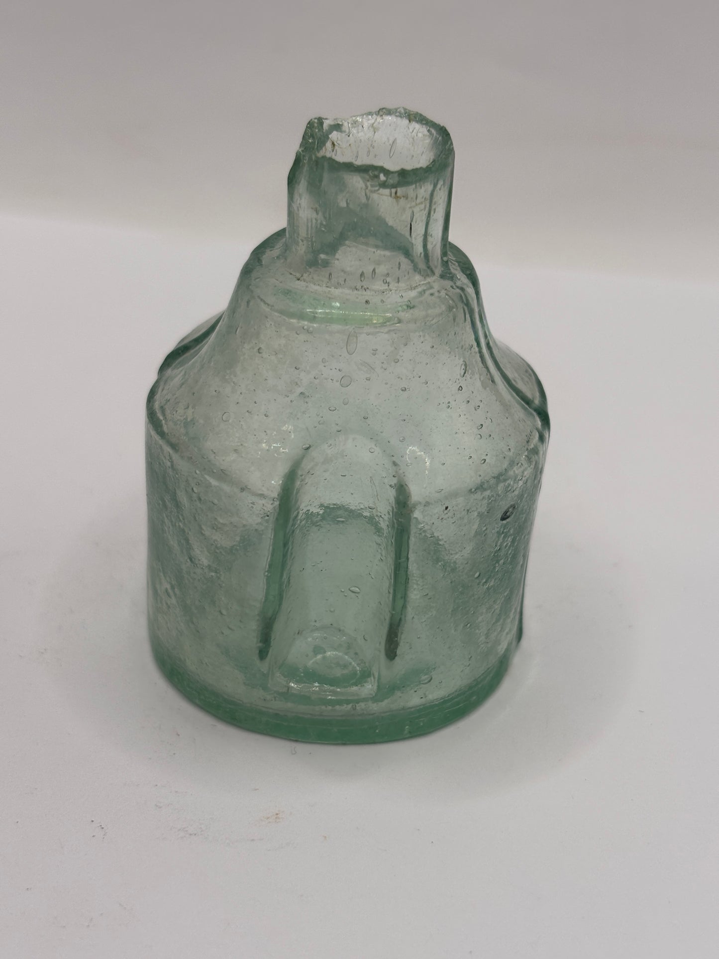 Old round aqua glass inkwell. Ink bottle with pen rest