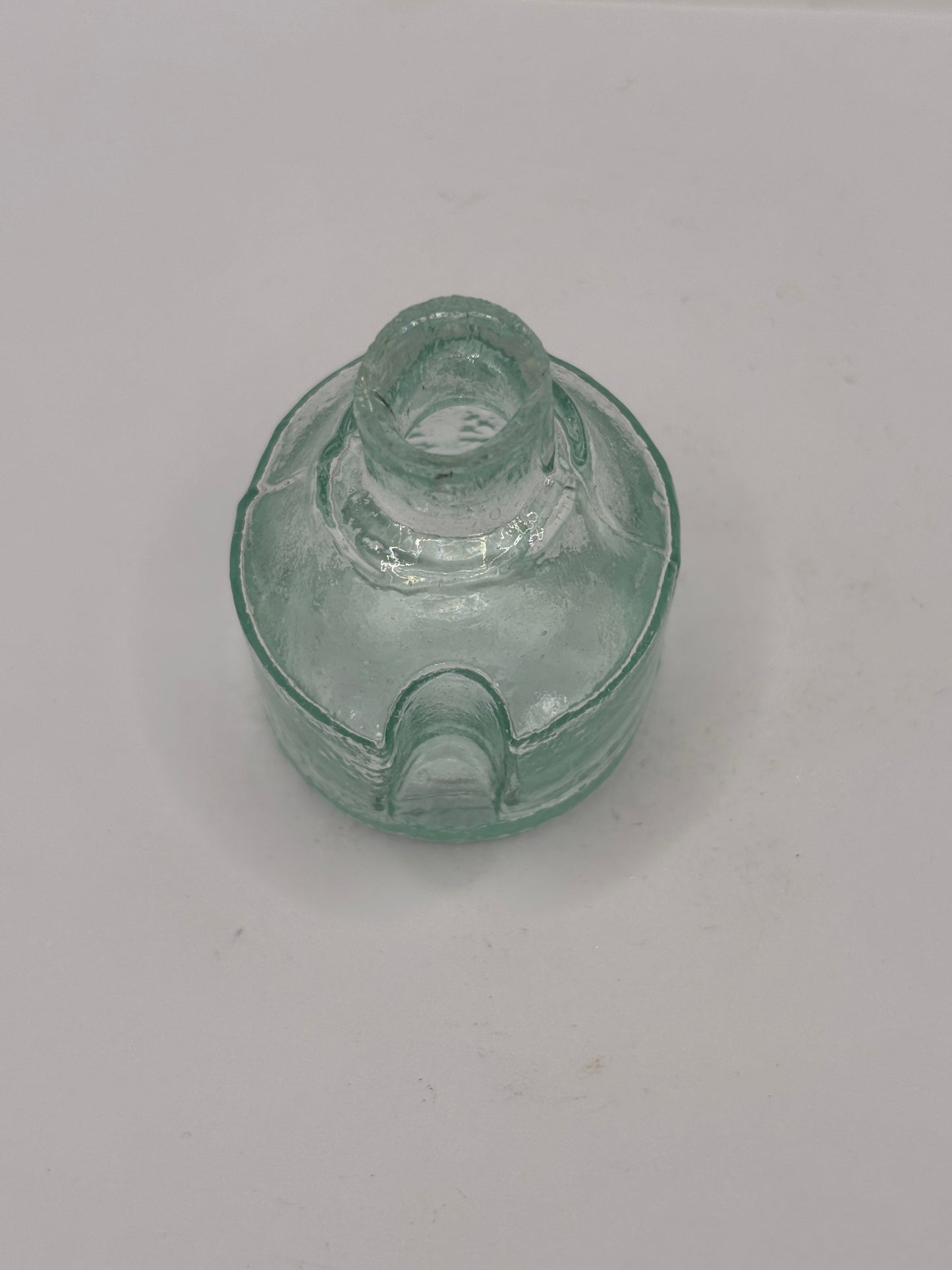 Old aqua glass inkwell. Ink bottle with pen rest
