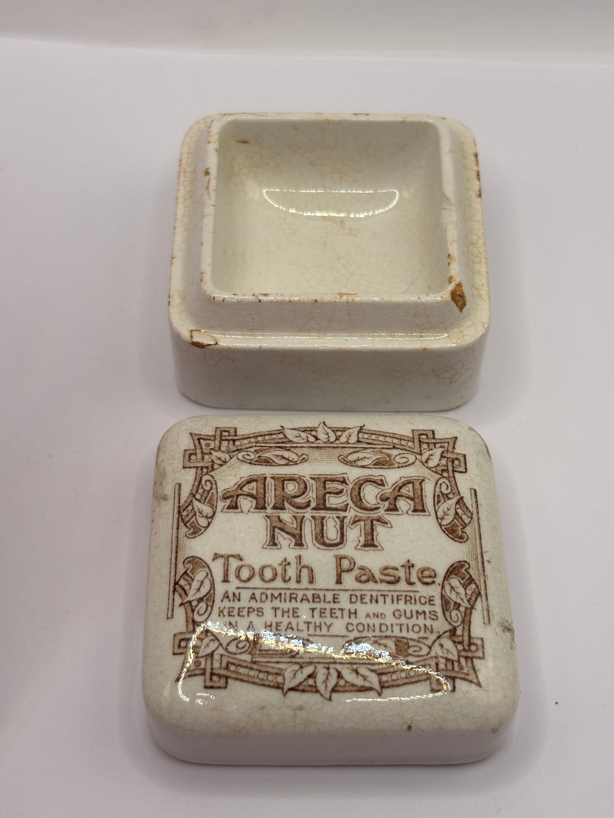 Old advertising lid and base. Areca nut toothpaste. Serpia print. Damaged