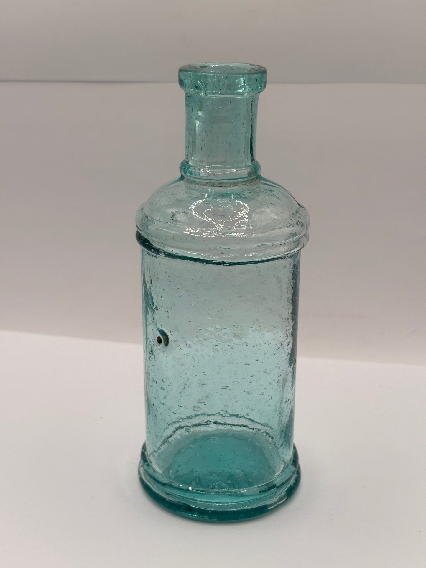 Old tall aqua glass pouring ink, ink bottle