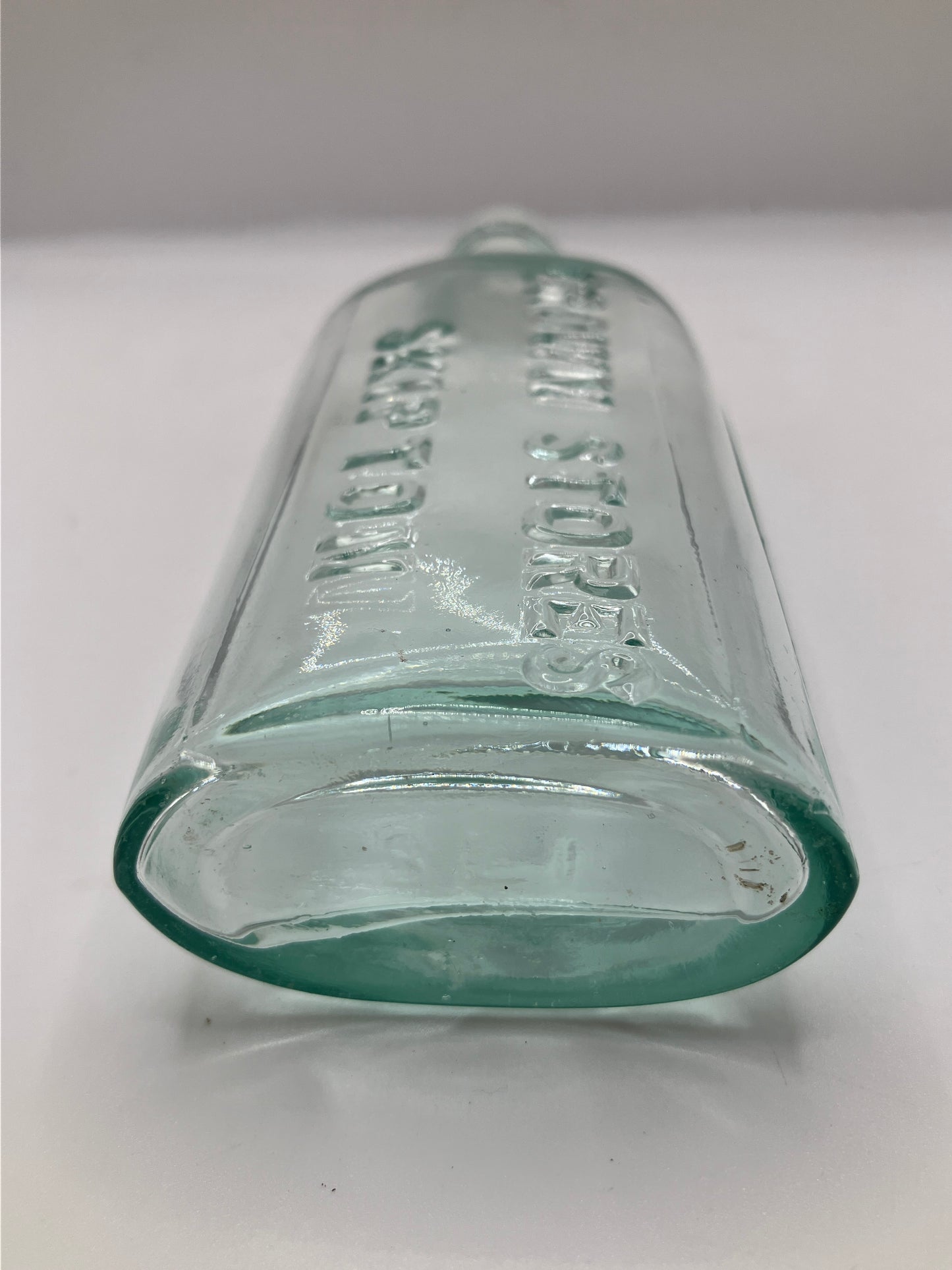 Aqua glass advertising spirit flask, Skipton