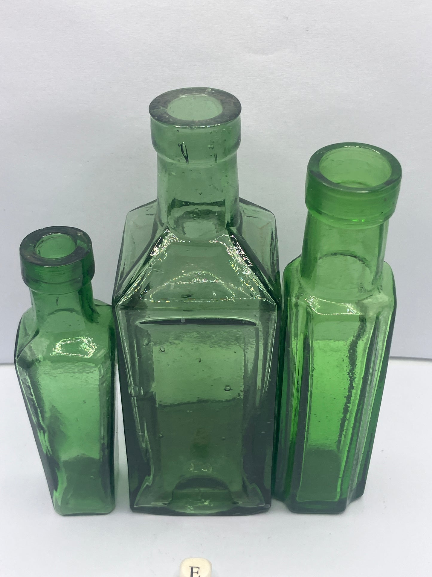 3 tall green glass bottles