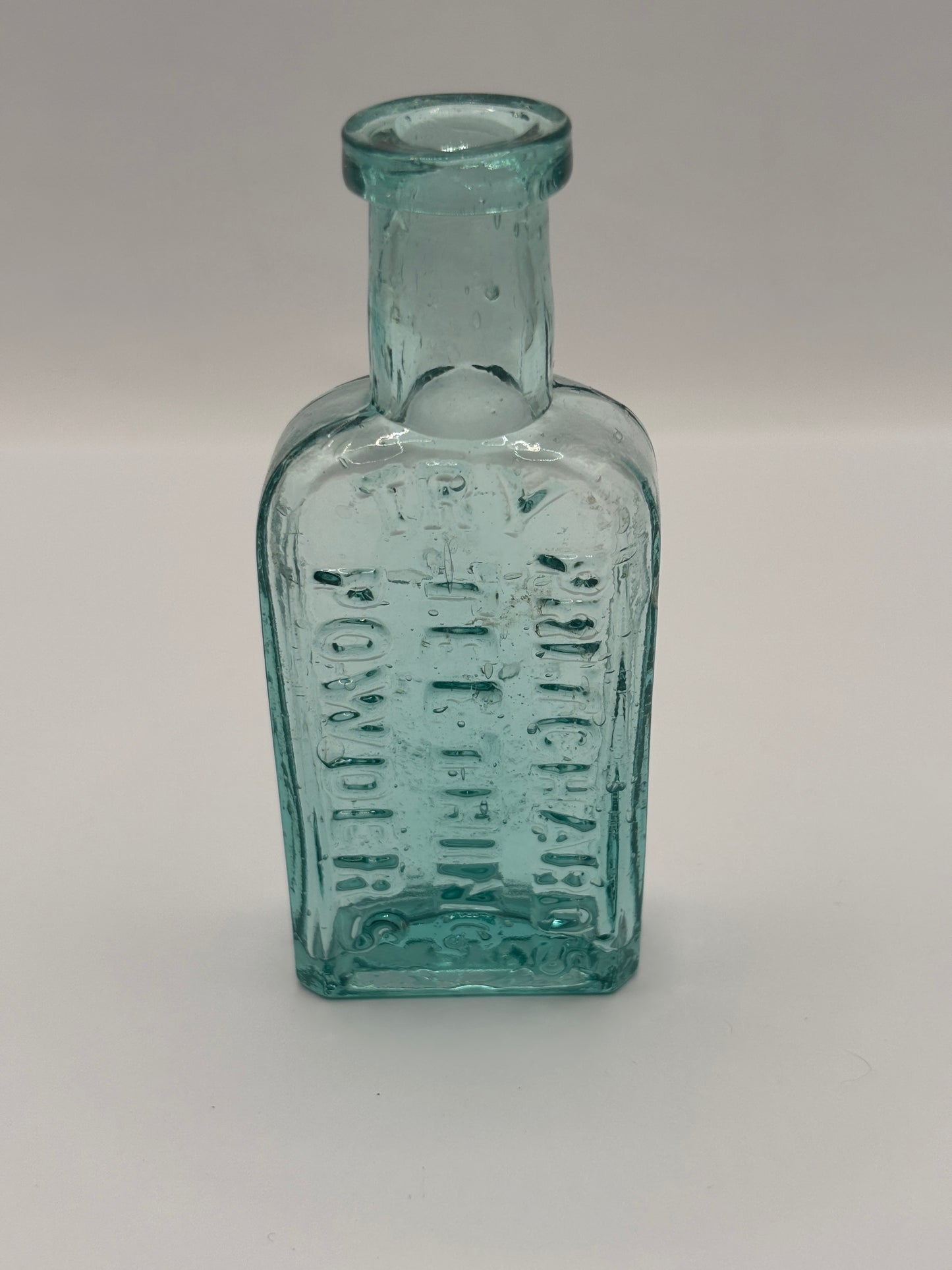 Old small aqua glass advertising bottle. Pritchards teething powders