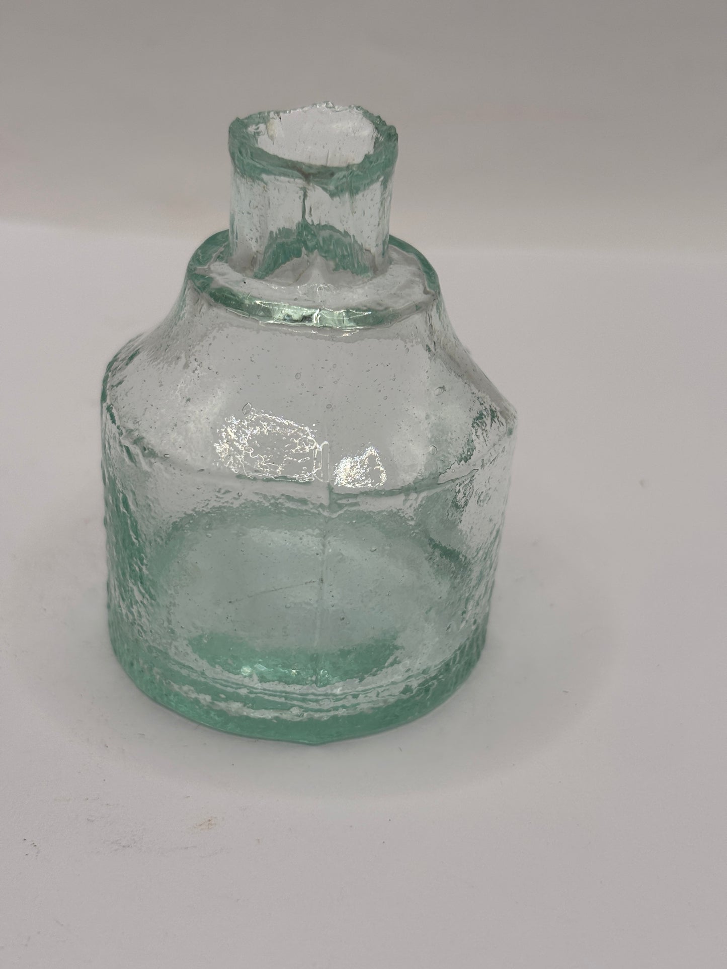 Old aqua glass inkwell. Ink bottle with pen rest