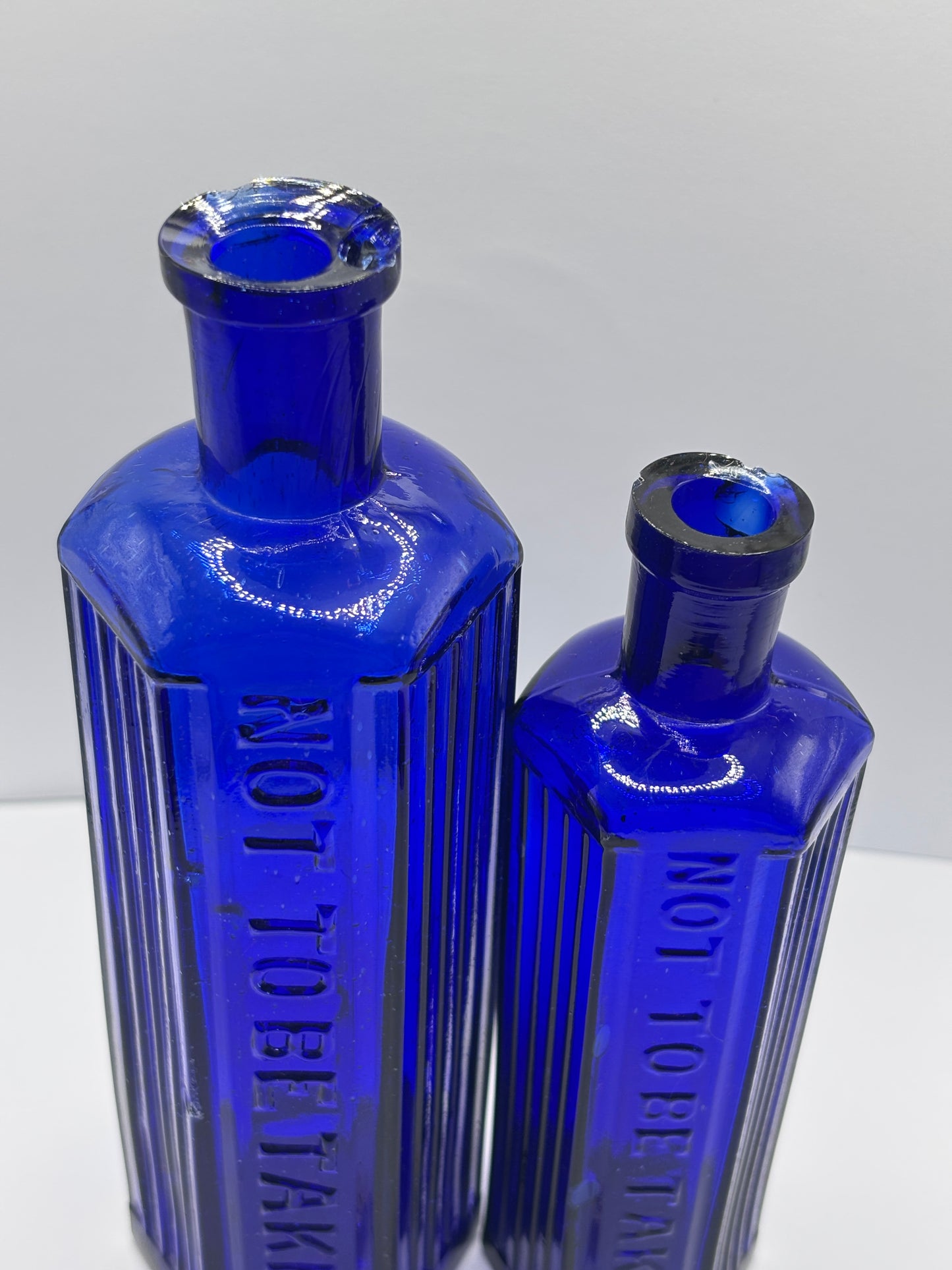2 Old blue glass ribbed poison bottles. ‘not to be taken’ (C) damaged