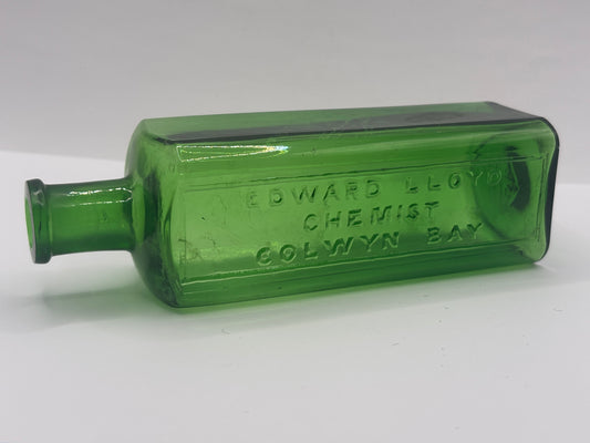 Old green glass advertising chemist bottle. Edward Lloyd chemist Colwyn bay