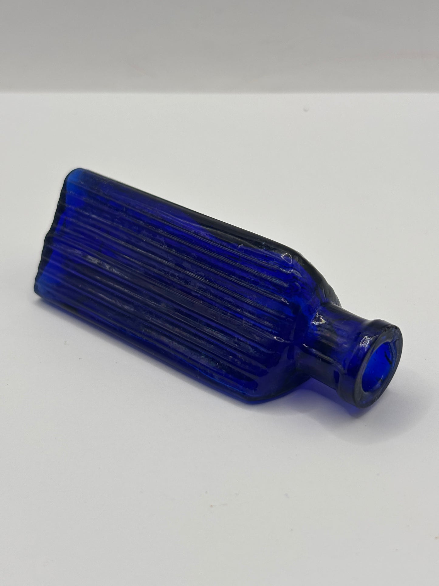 Old small blue triangular poison bottle