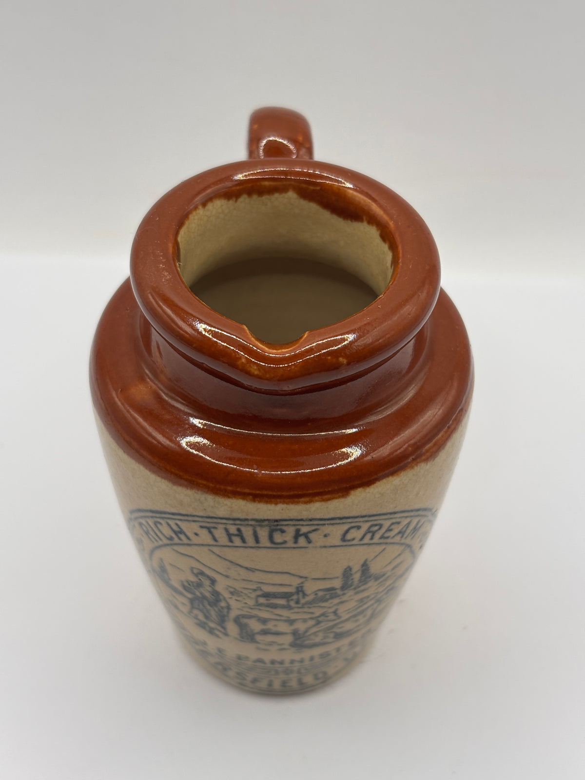 Old advertising cream pot, Bannisters Huddersfield dairies. Repaired handle