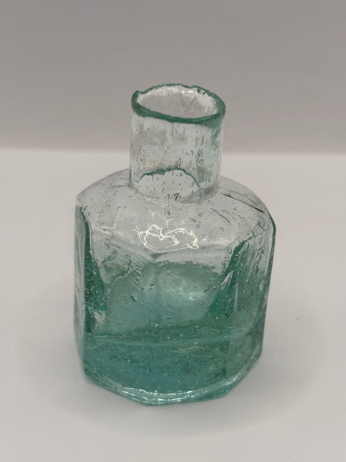 Old aqua glass inkwell, bubbly ink