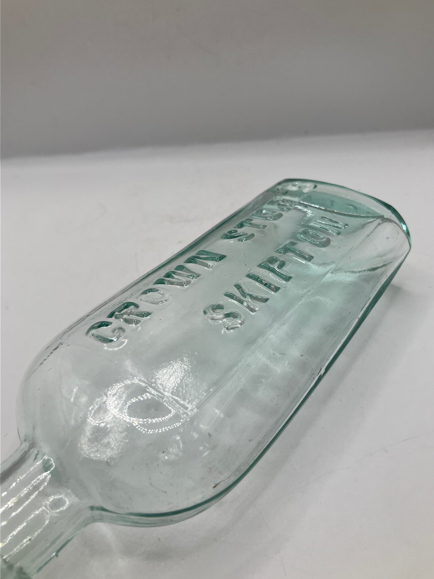 Aqua glass advertising spirit flask, Skipton