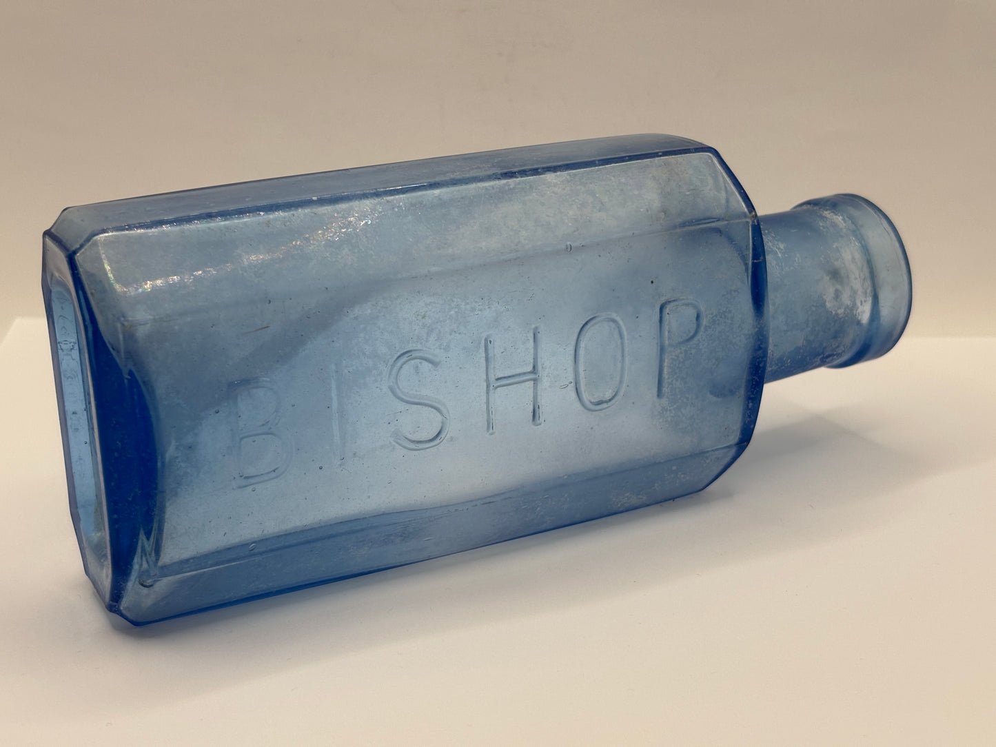 Old crusty blue glass advertising chemist bottle, Bishop