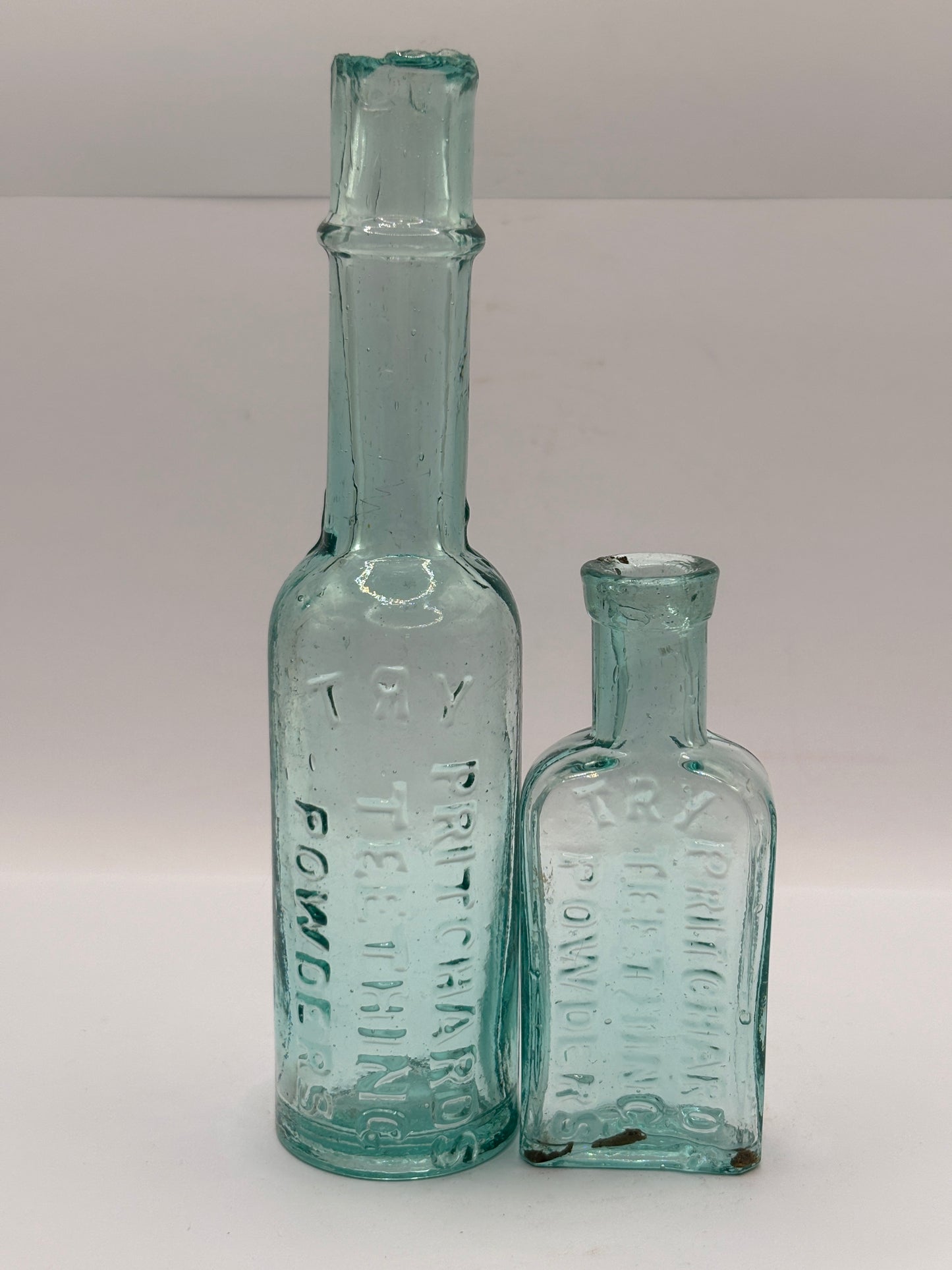 Old aqua glass advertising bottles. Pritchard teething powders