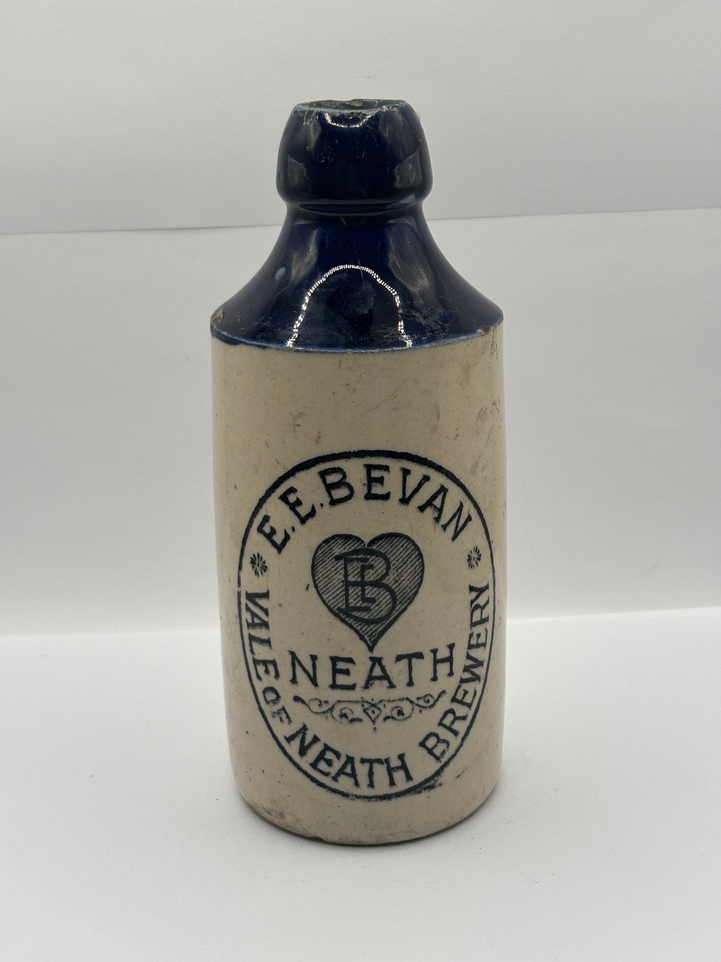 Old blue top stoneware ginger beer bottle, E.E Bevan Neath Brewery