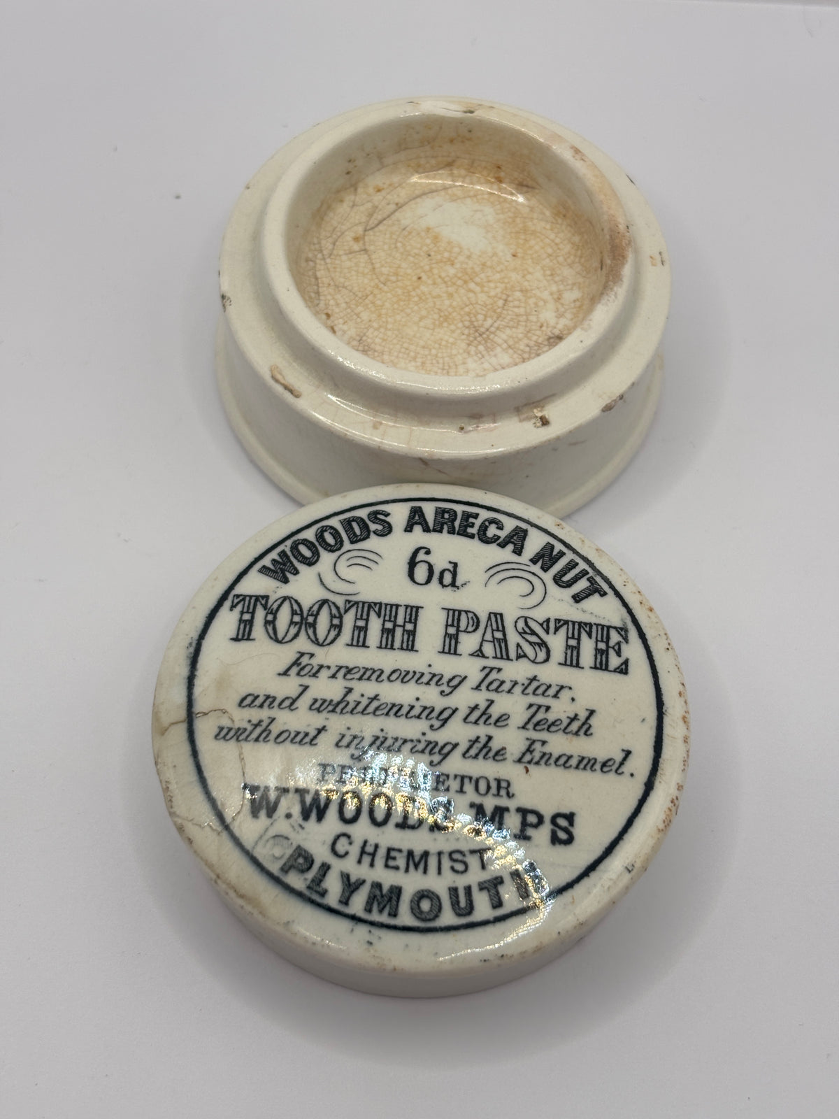 Old advertising lid and base. Woods areca nut tooth paste. Damaged