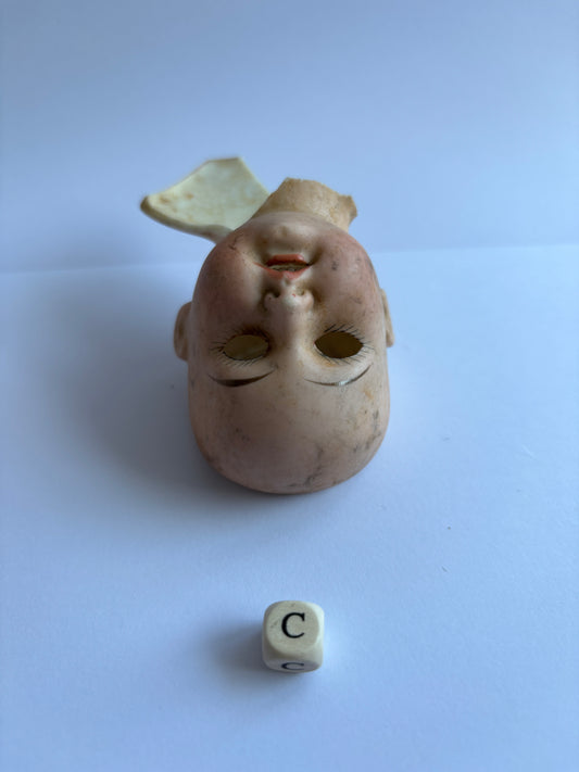 crusty old dolls head, damaged (c)
