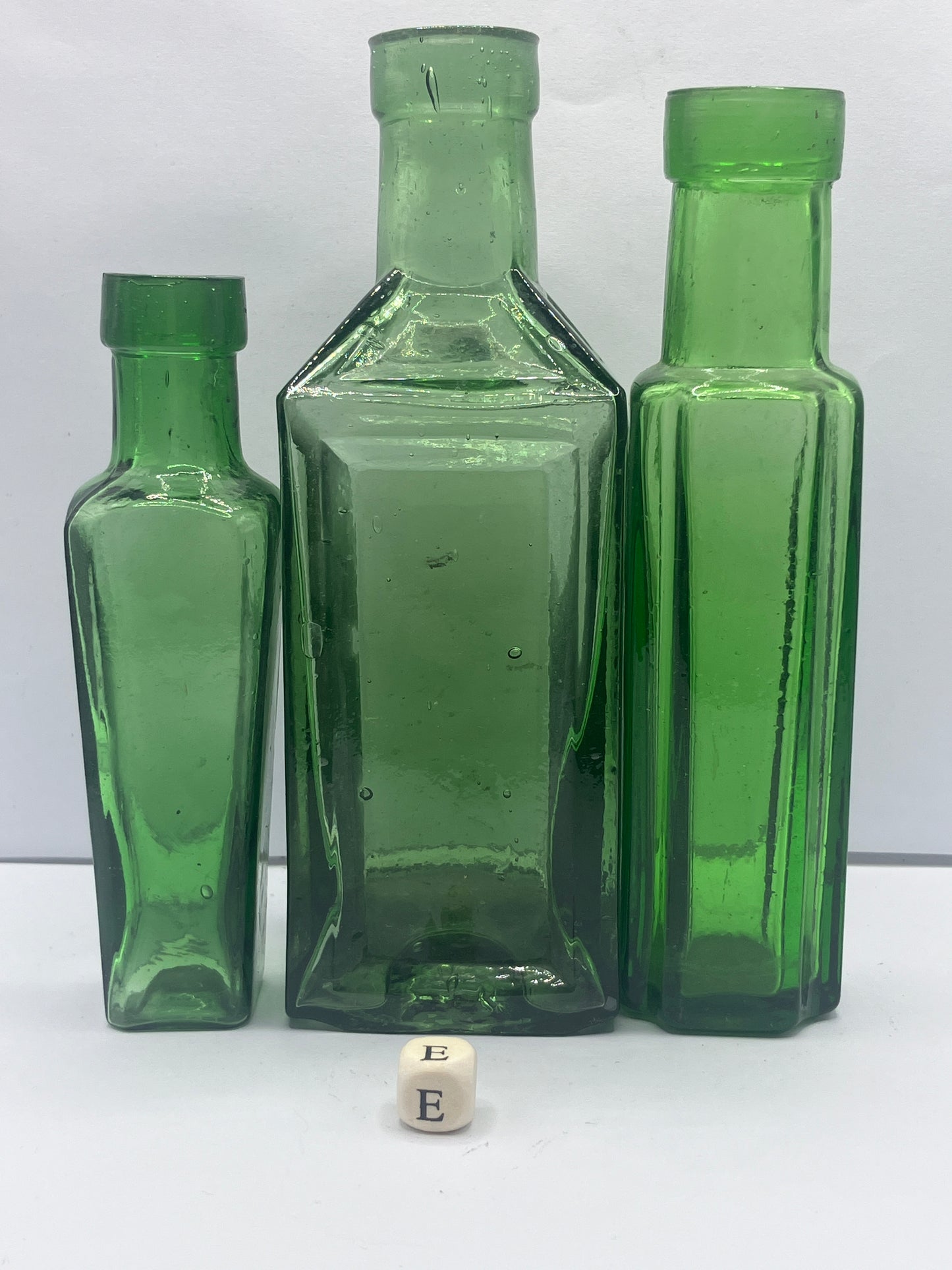 3 tall green glass bottles