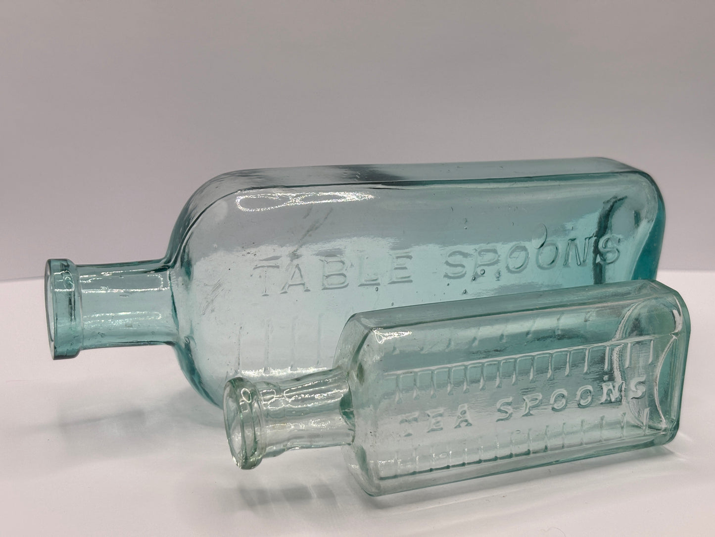 2 old aqua glass tablespoon & teaspoon bottles