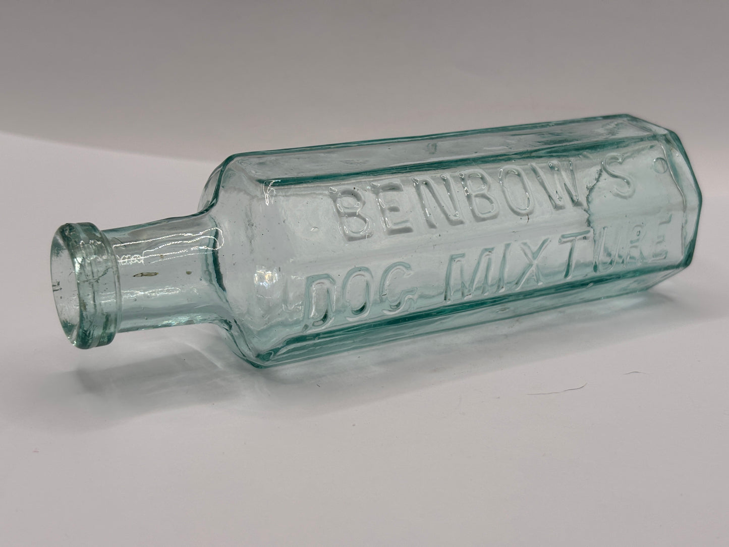Old aqua glass advertising bottle. Benbows dog mixture